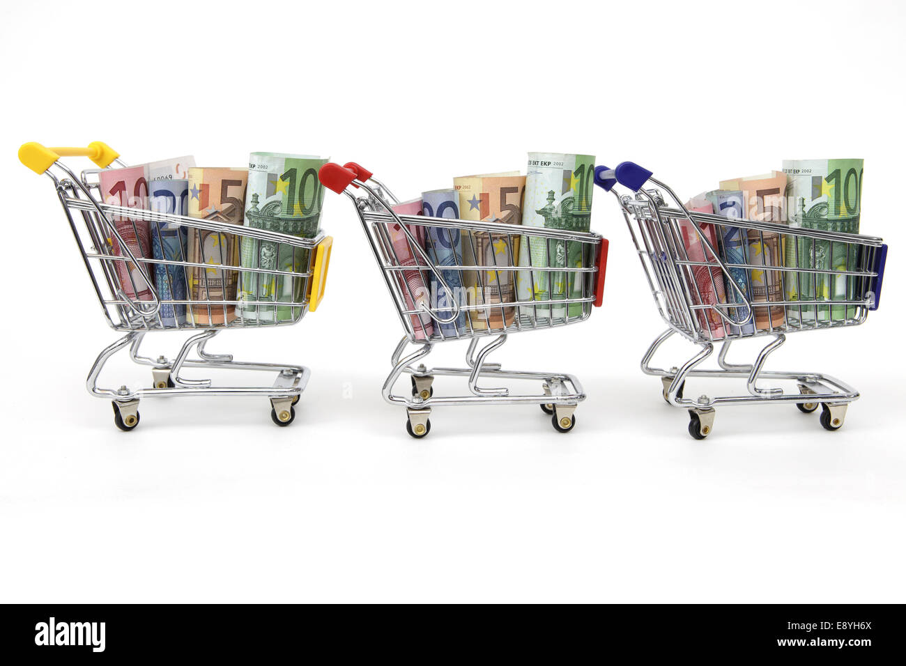 Drei Shopping Carts mit Geld in einer Reihe Stockfoto