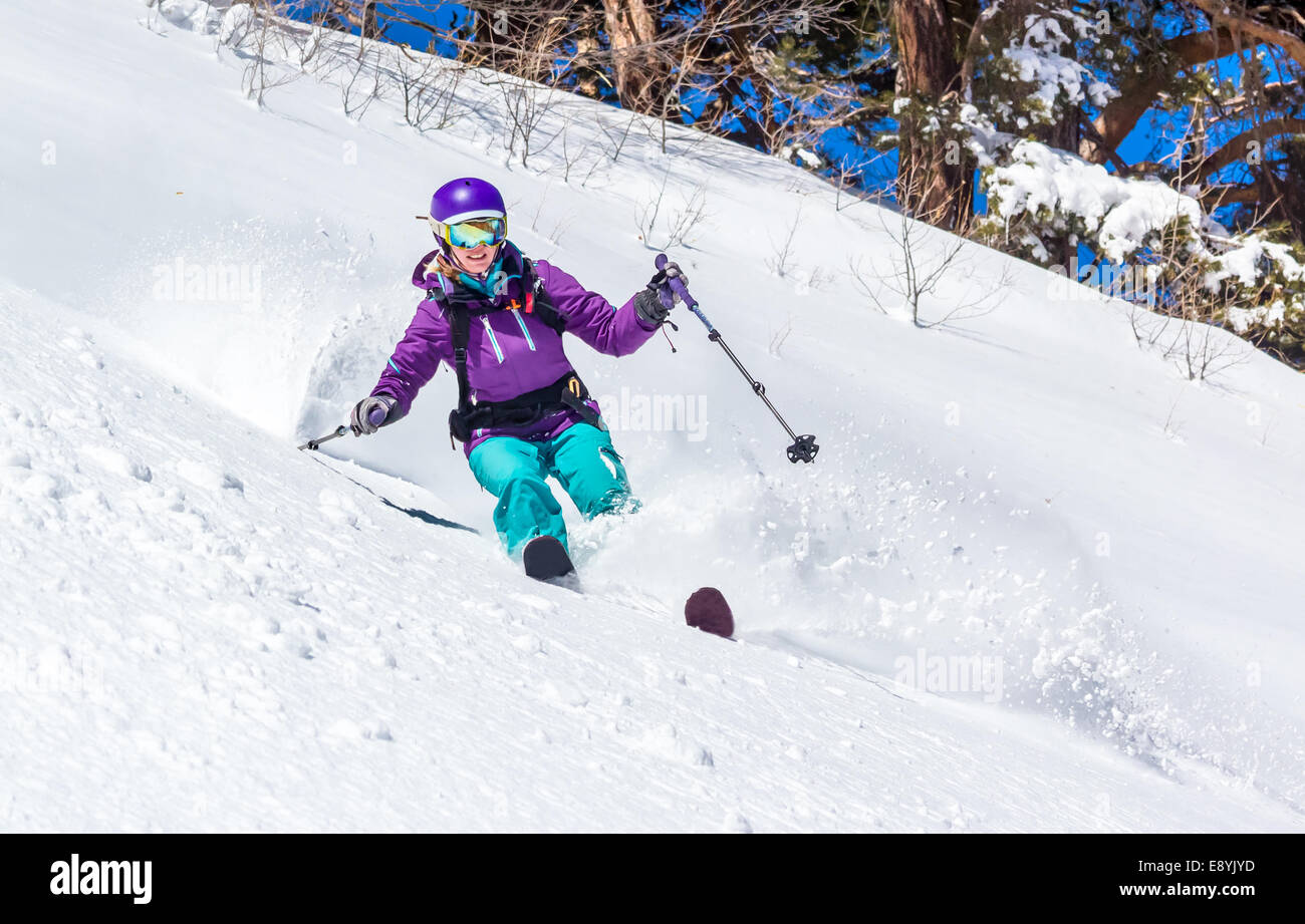 Skifahrerin im Tiefschnee. Off-Piste Skifahren im weichen Schnee an einem kalten, sonnigen Tag in der Waldzone Stockfoto