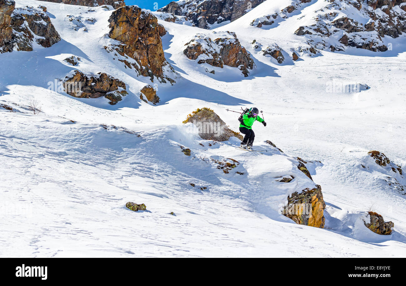 Frau Skifahrer Sprung von einer Klippe in den Bergen an einem sonnigen Tag Stockfoto