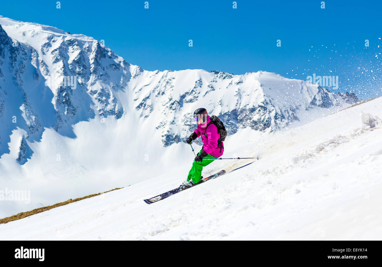 Abseits der Pisten auf dem Hintergrund der hohen Berge Skifahrer. Im Gegenzug wirft den Schnee Staub. Stockfoto