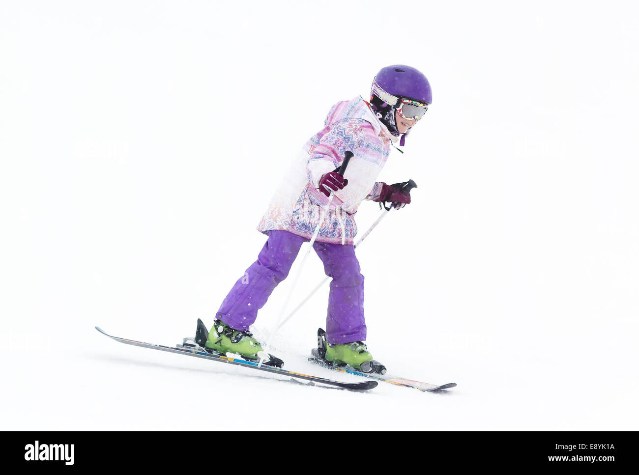Kleines Mädchen auf Skiern in den Bergen im Nebel auf der Suche nach dem Weg Stockfoto