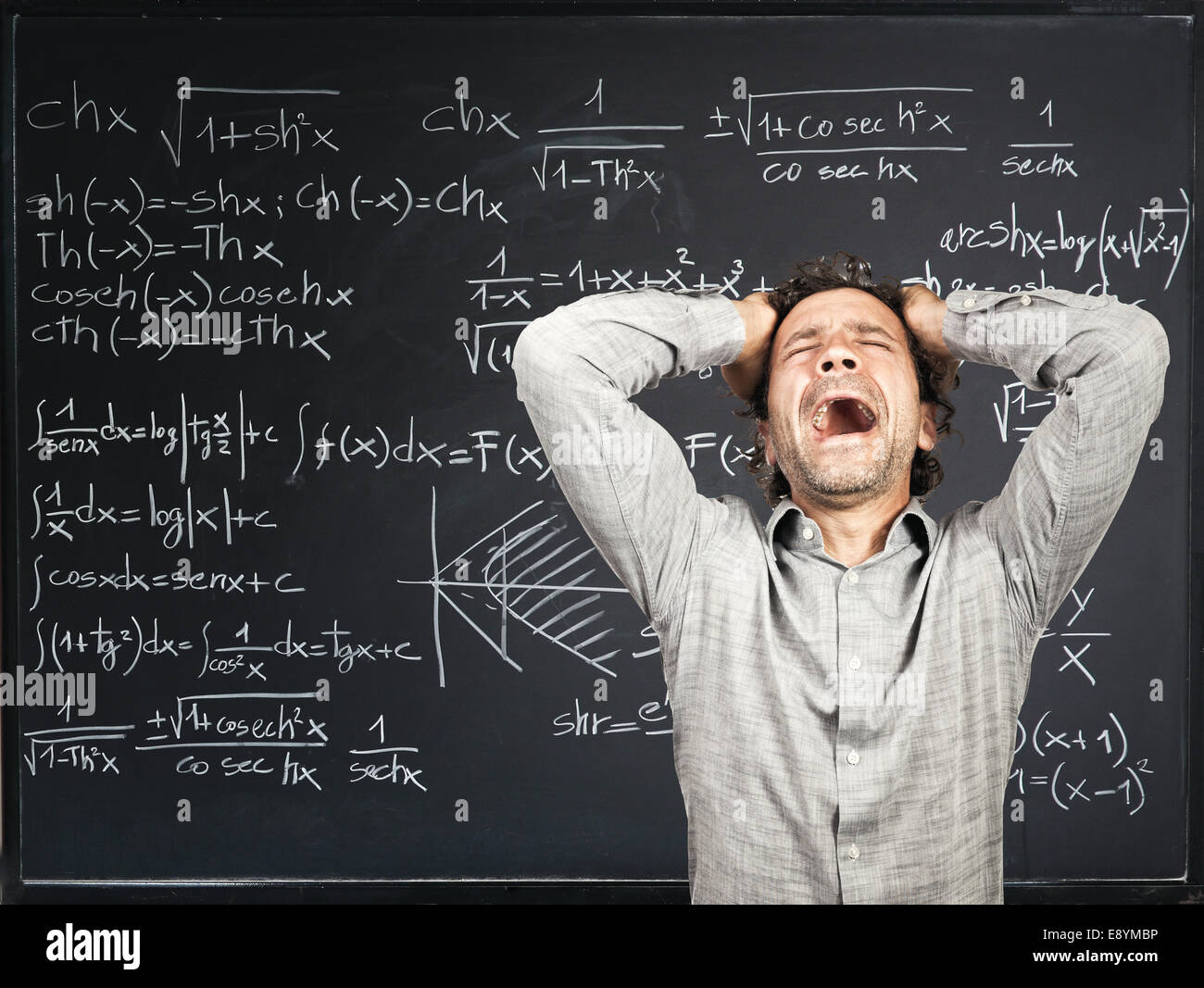 verzweifelte Lehrer und Blackboard-Hintergrund Stockfoto