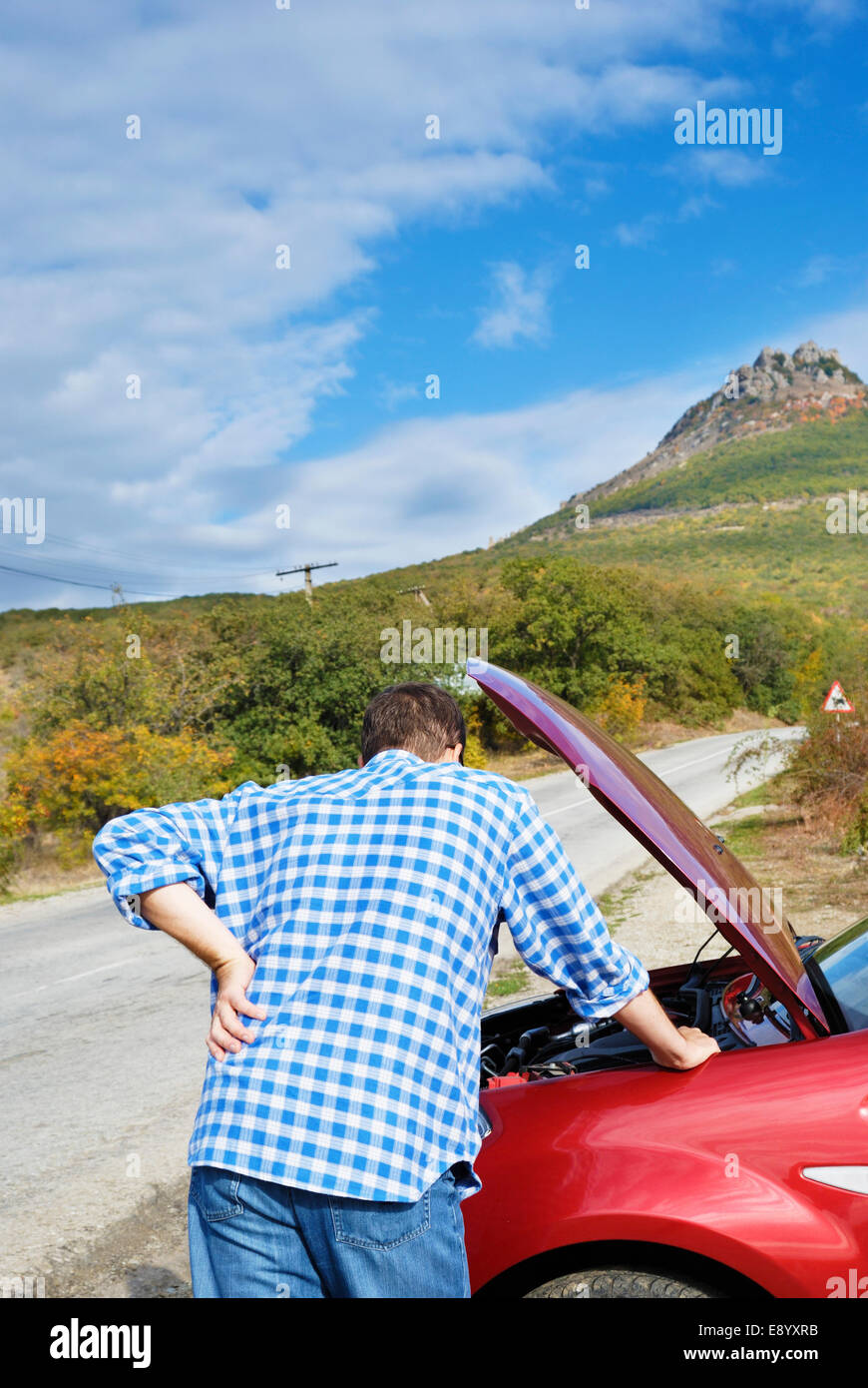 Erwachsener Mann steht in der Nähe von seinem kaputten Auto warten auf Schlepp Stockfoto