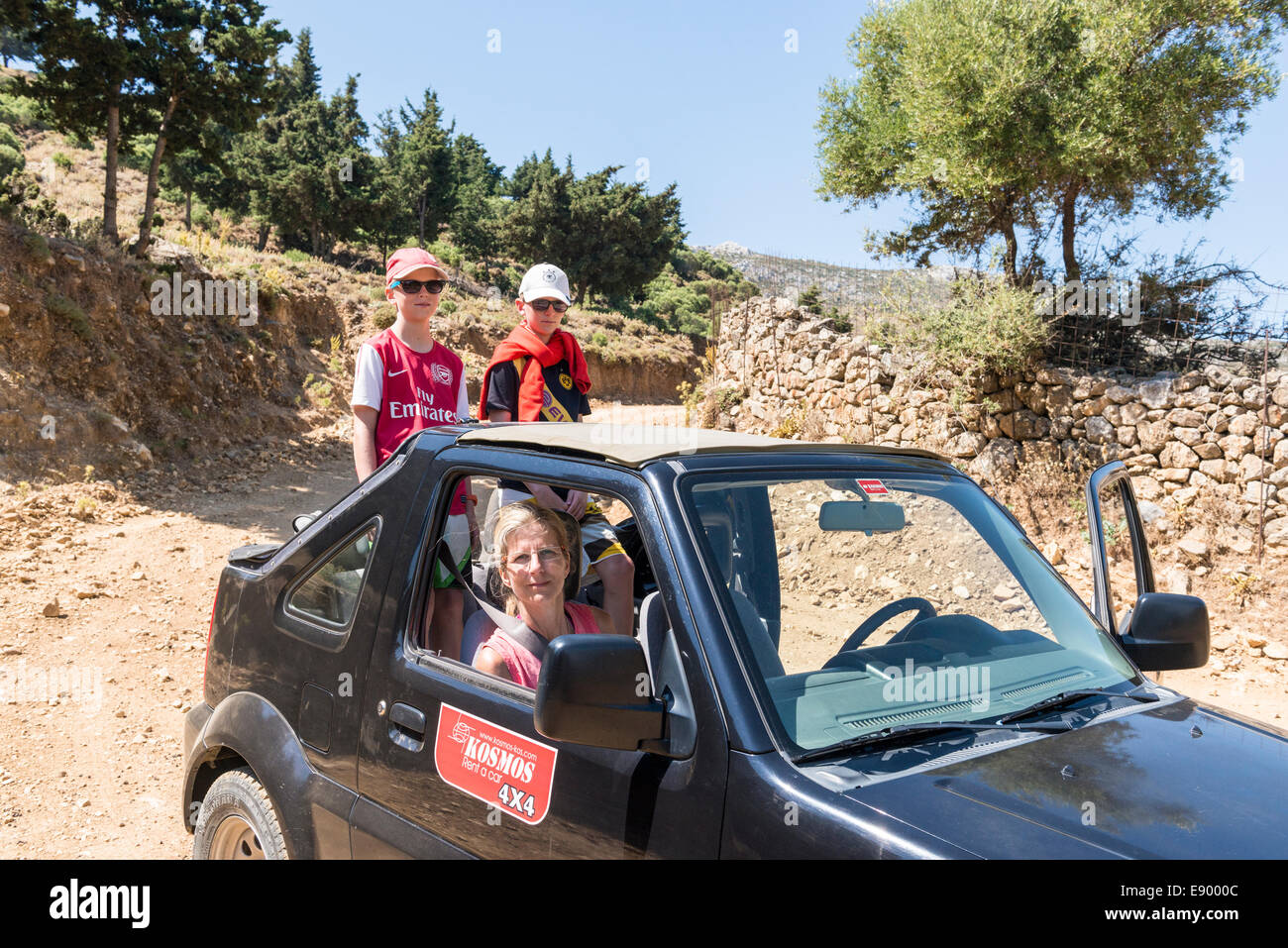 Mother with two children driving in an open jeep up the mountains to Pyli, Kos, Greece Stockfoto