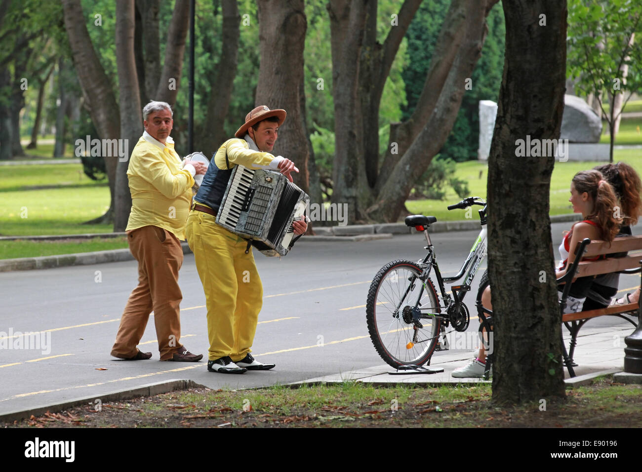 BURGAS, Bulgarien - 23. Juli 2014: Straße Musiker spielen für Mädchen in den Seepark Stockfoto