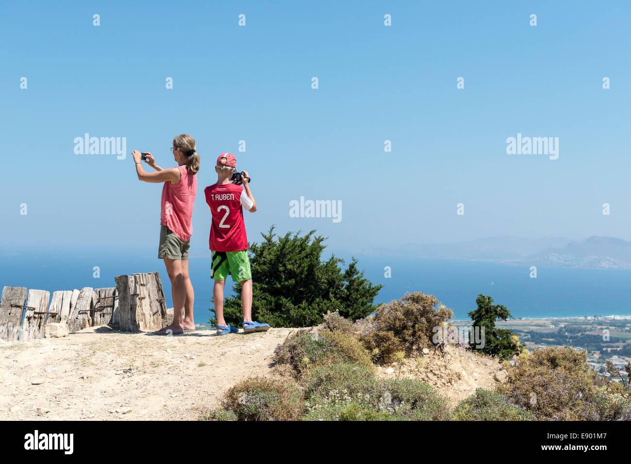 Mutter und Sohn fotografieren von einem Aussichtspunkt in den Bergen von Pili, Insel Kos, Griechenland Stockfoto
