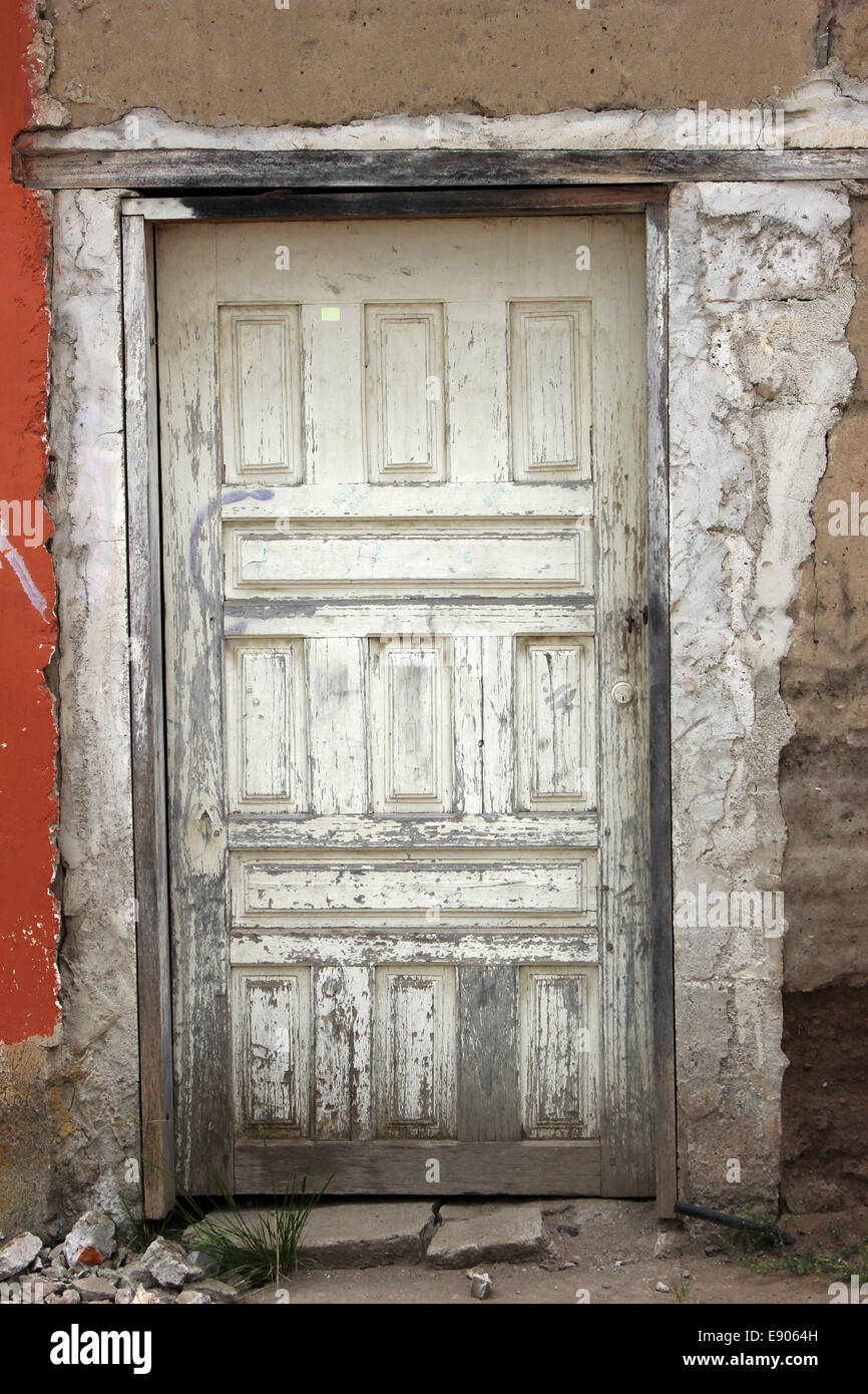 Eine weiße Holztür in eine Adobe-Mauer an einem Gebäude in Cotacachi, Ecuador Stockfoto