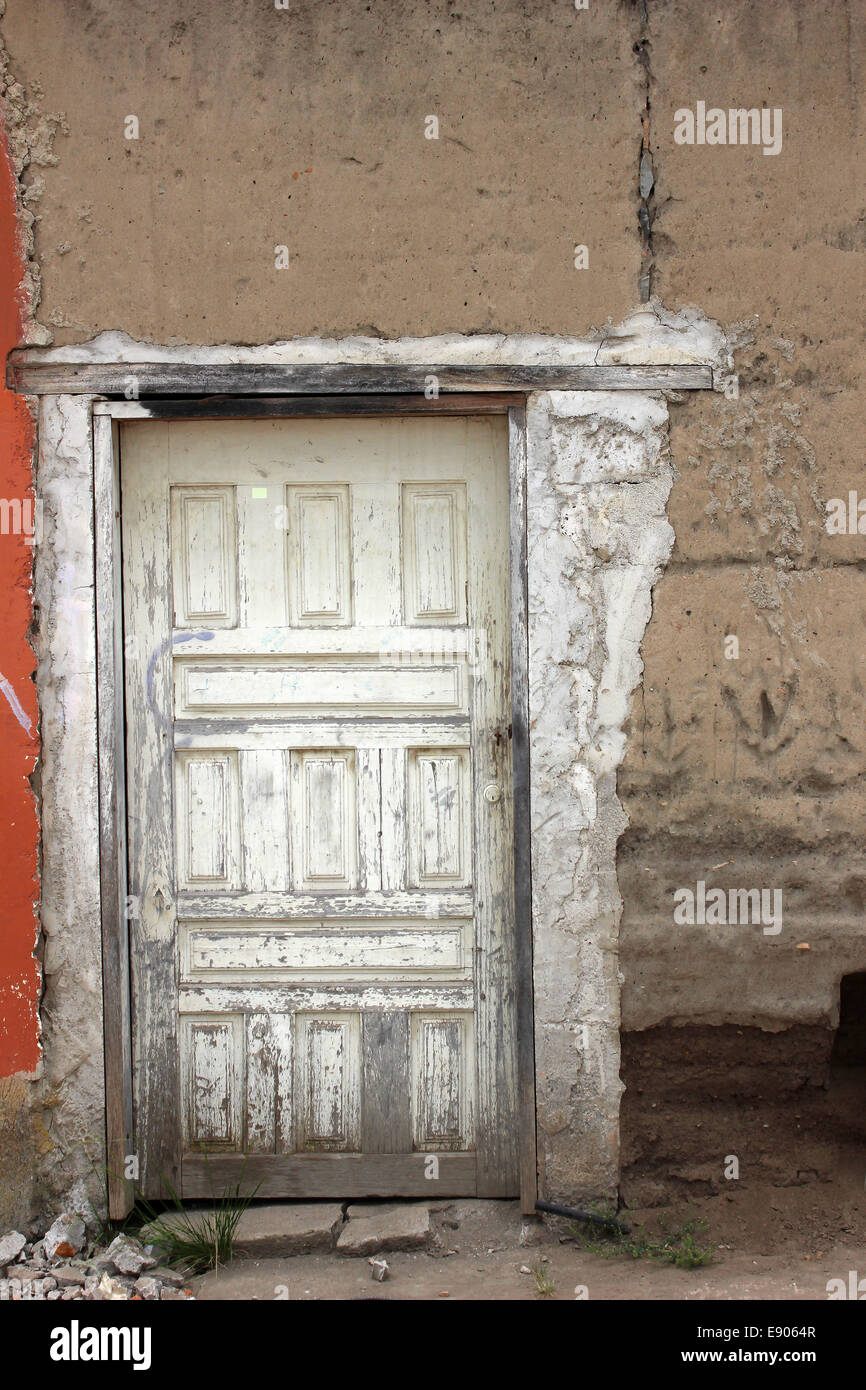 Eine weiße Holztür in eine Adobe-Mauer an einem Gebäude in Cotacachi, Ecuador Stockfoto