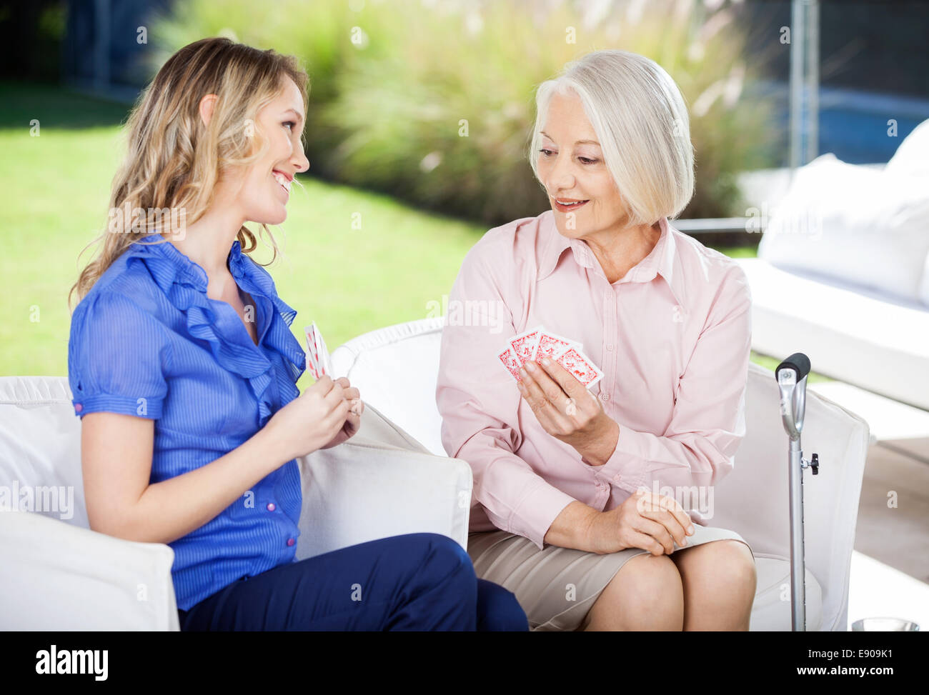 Glückliche Enkelin, die Spielkarten zu Großmutter Stockfoto