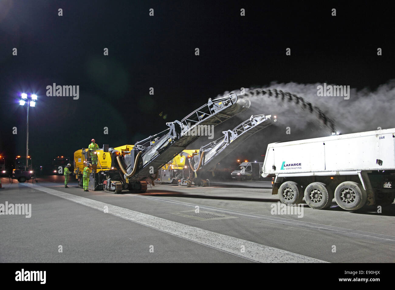 Flughafen Heathrow, London. Wartungsteams tauchen die Südbahn während einer Nachtschließung wieder auf. Zwei Straßenflugzeuge entfernen die obere Fläche. Stockfoto