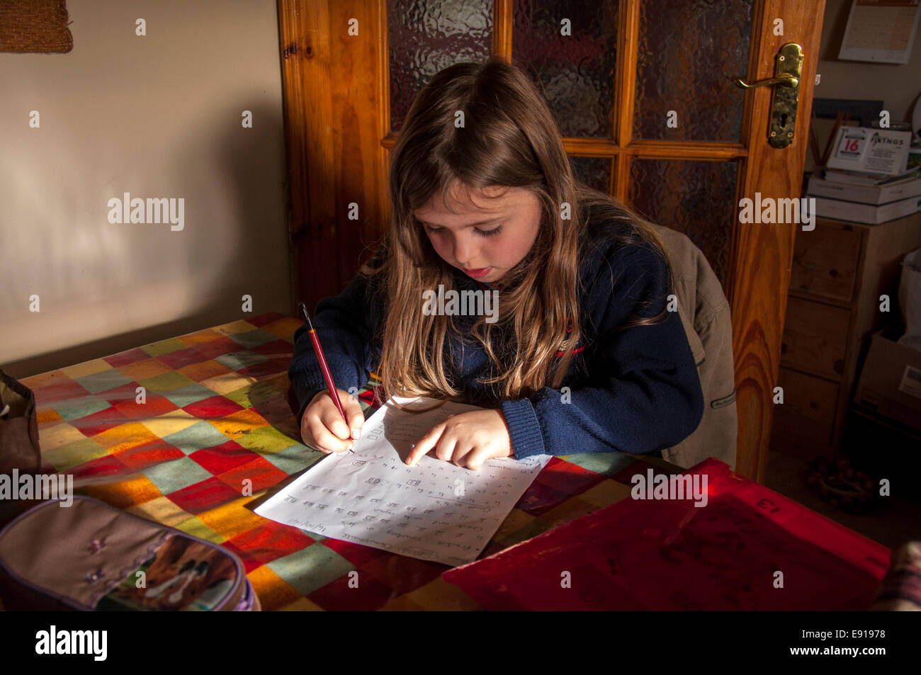Sieben Jahre alten Irin Hausaufgaben am Küchentisch in Donegal Ireland Stockfoto