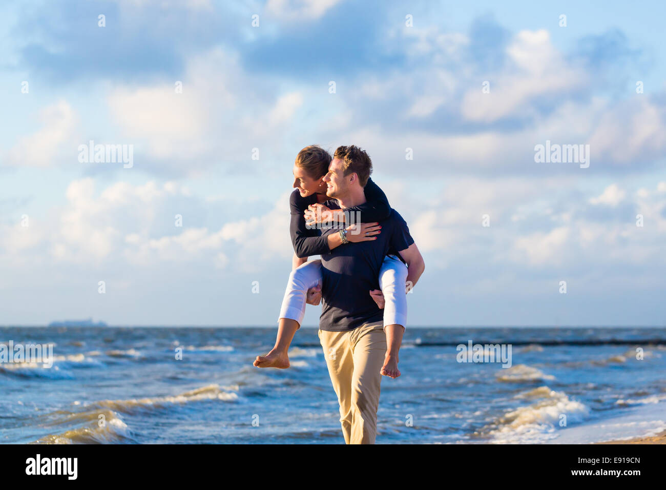 Paar genießt romantischen Sonnenuntergang am deutschen Nordseestrand Stockfoto
