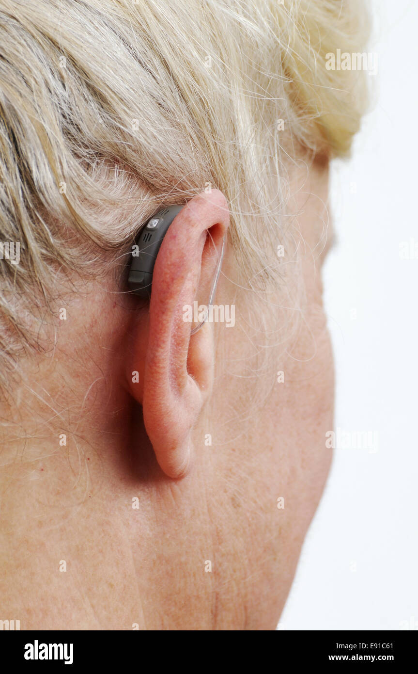 Moderne kleine Hörgerät hinter dem Ohr einer Frau Stockfoto
