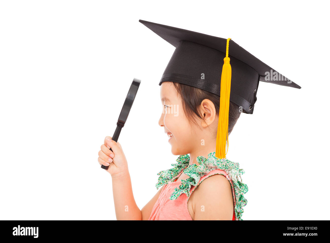 glückliche kleine Schulmädchen hält eine Lupe Stockfoto