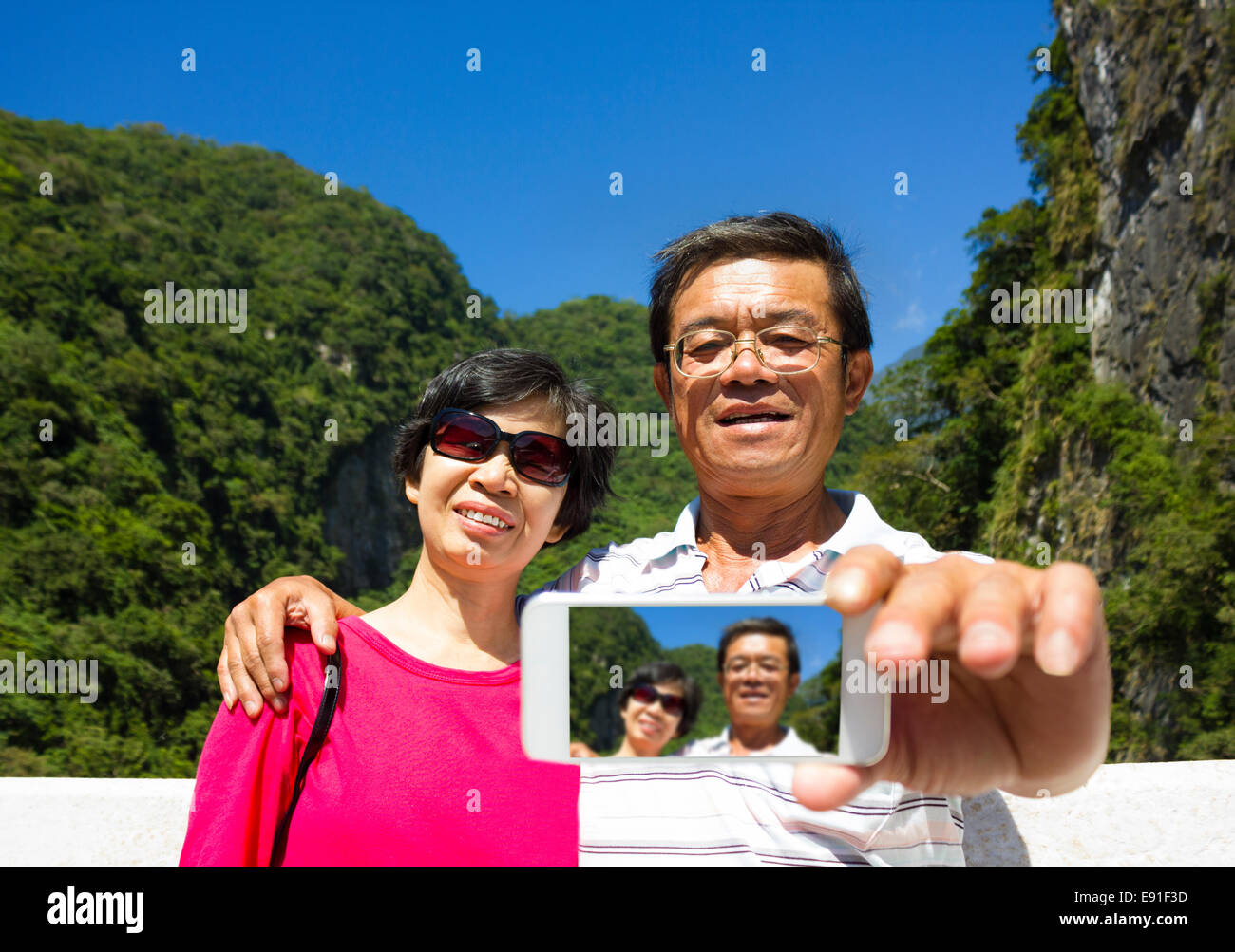 Älteres paar unter Bild von sich selbst außerhalb mit Gebirgshintergrund Stockfoto