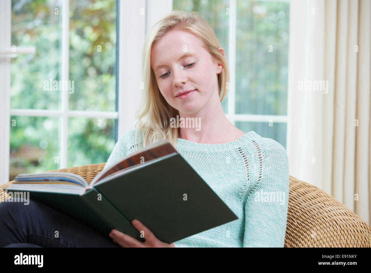 Teenager-Mädchen sitzen zu Hause Lesebuch Stockfoto