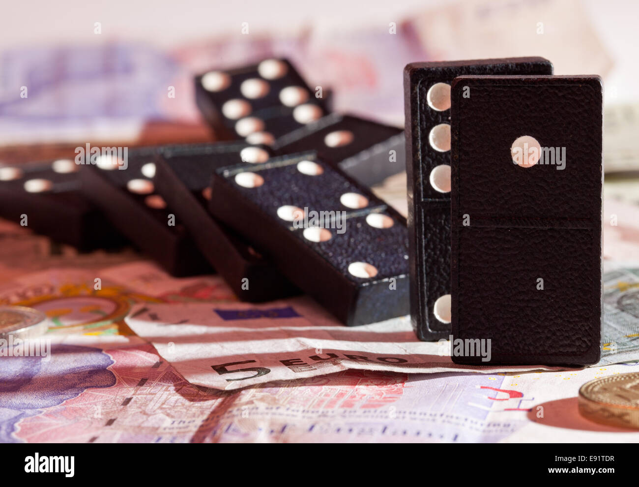 Gefallenen Dominos auf Banknoten Stockfoto