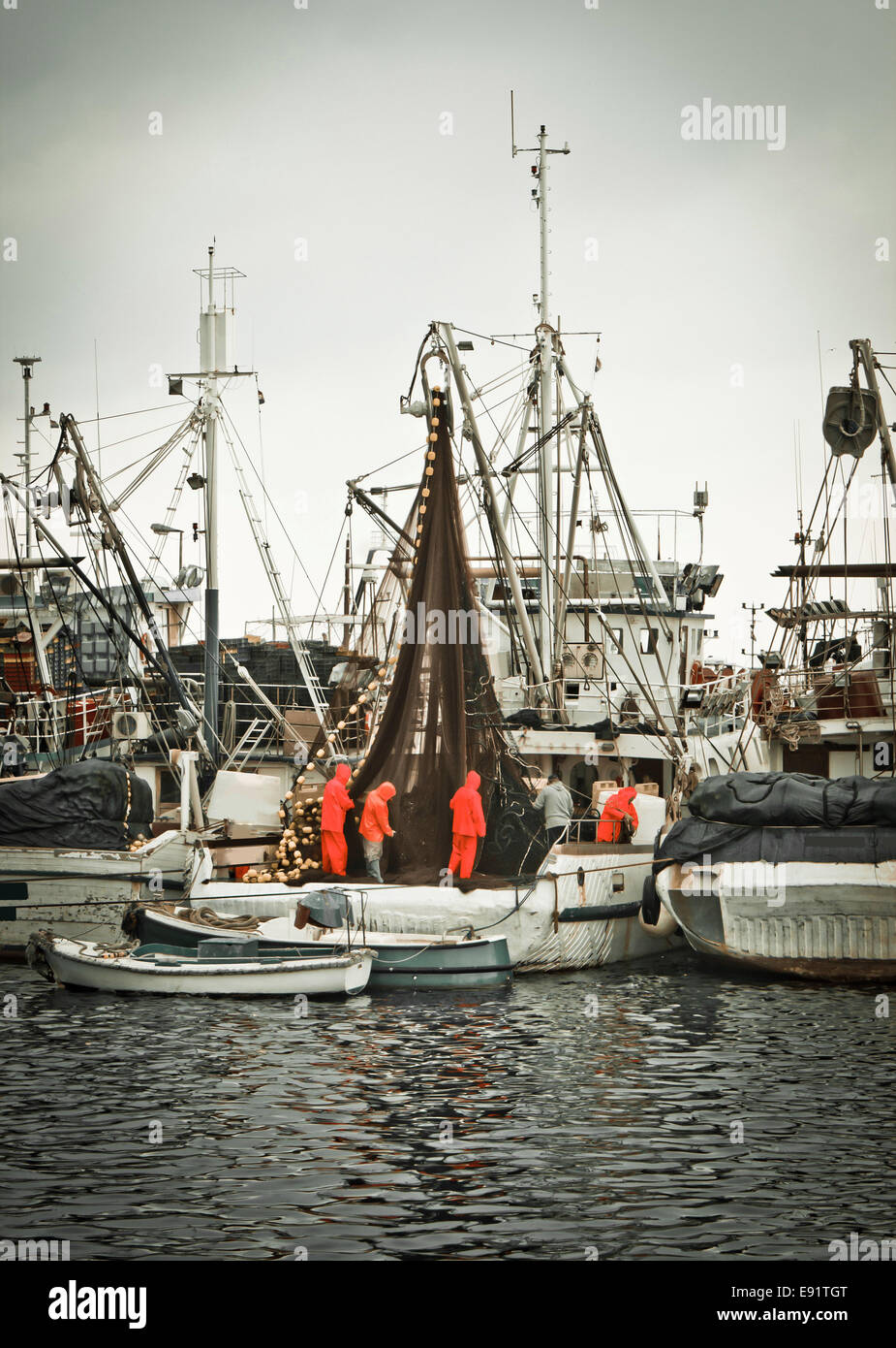 Fischer-Crew, die Befestigung der Netze am Fischerboot Stockfoto