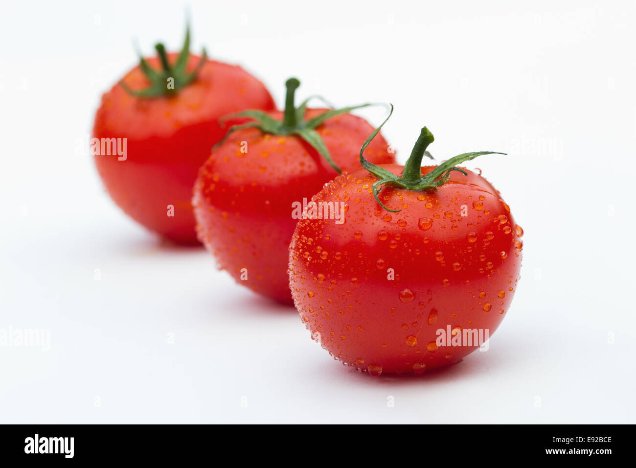 drei Tomaten eins nach dem anderen Stockfoto