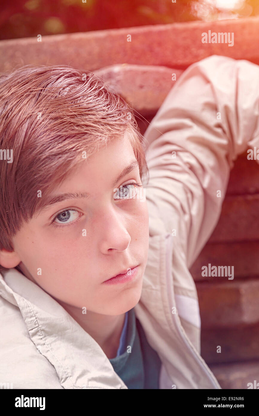 Bild von einem coolen Teenager stützte sich auf einen Stapel von Steinplatten getönt Stockfoto