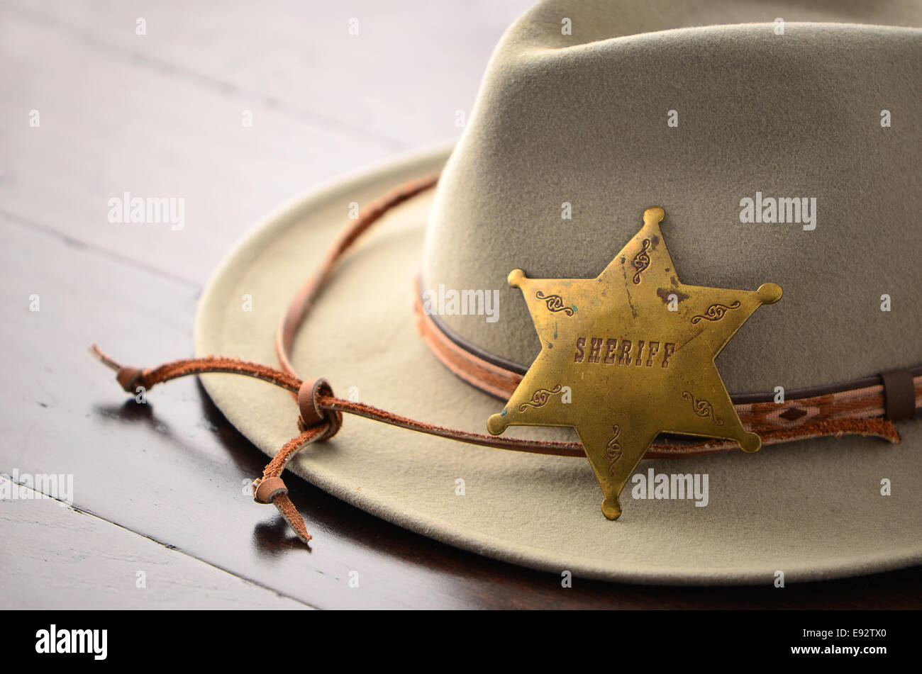 Cowboy-Hut mit Sheriff Abzeichen auf hölzernen Hintergrund im Querformat mit selektiven Fokus Stockfoto