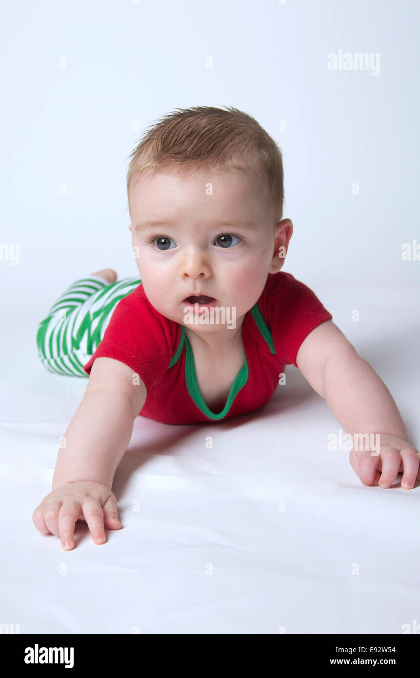 9 Monate altes Baby Boy hielt seinen Kopf trägt Weihnachtsfarben Stockfoto