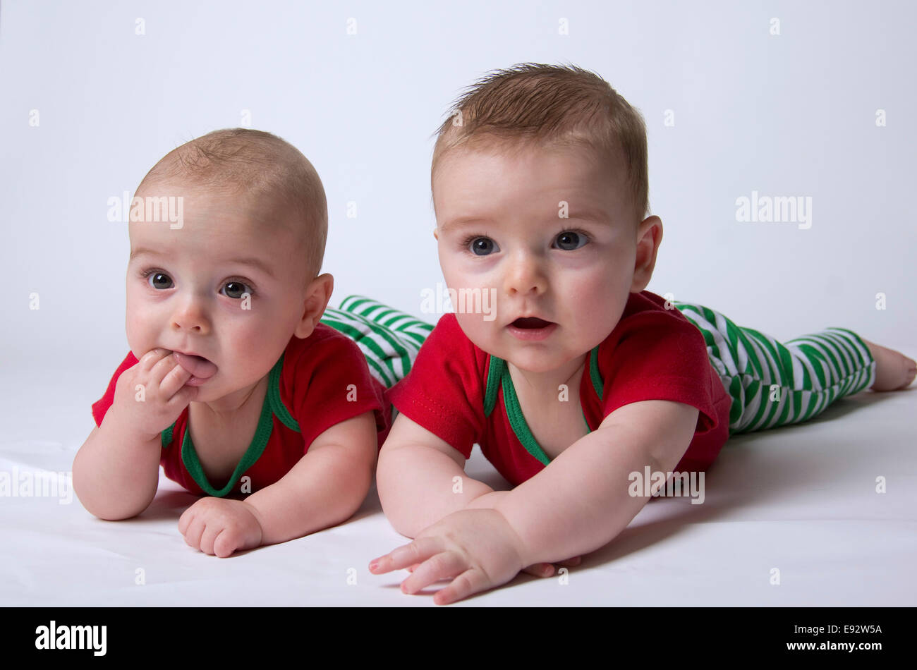 Brüderliche 9 Monat Zwillinge Jungen hielt ihren Kopf Ups und suchen Sie verdächtige oder unzufriedenen oder unsicher Stockfoto