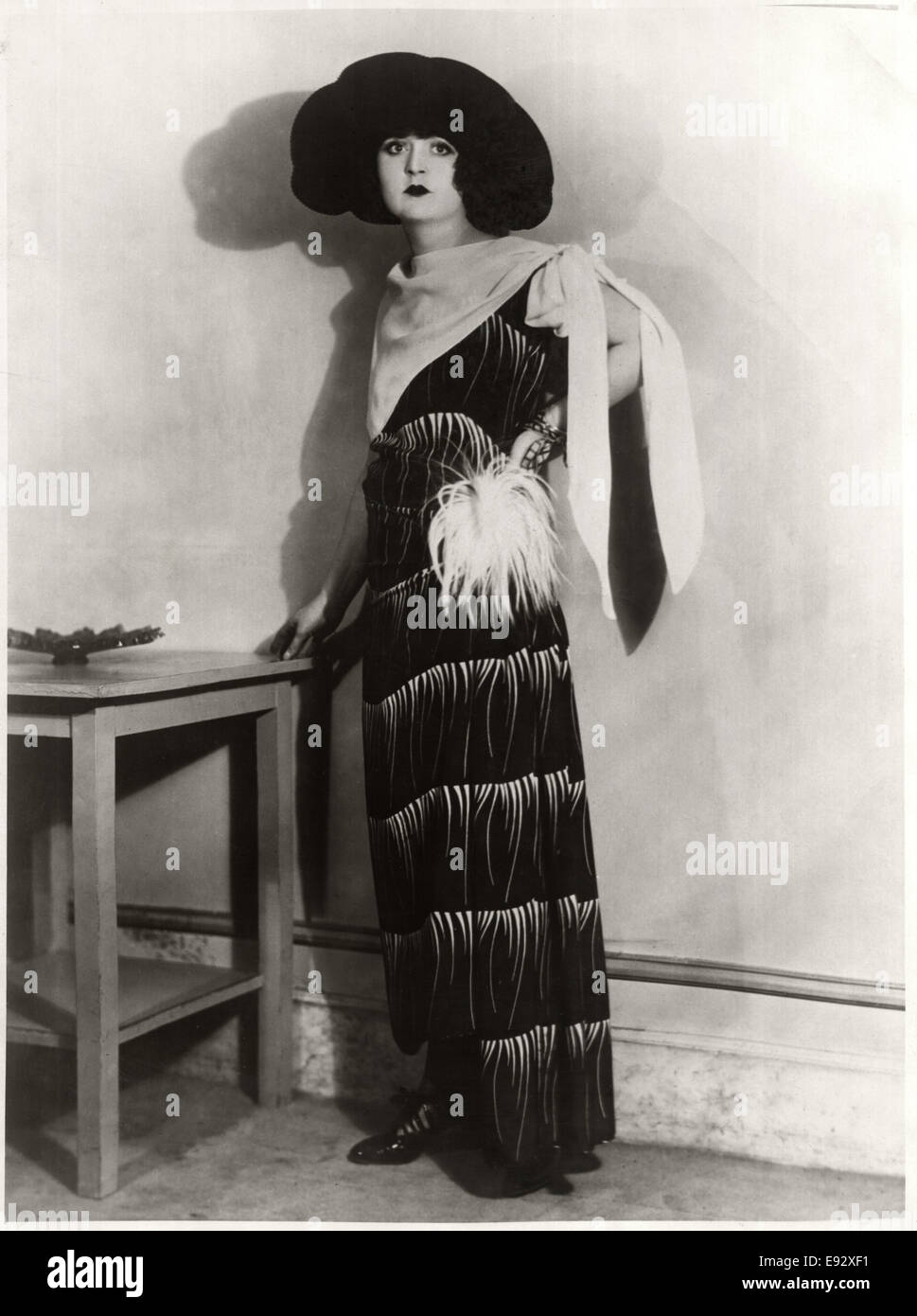 Modisch junge Frau im langen Kleid mit Feder Pompon an Taille und Crepe Tuch gebunden über die Schulter, mit Hut, Portrait, ca. 1922 Stockfoto