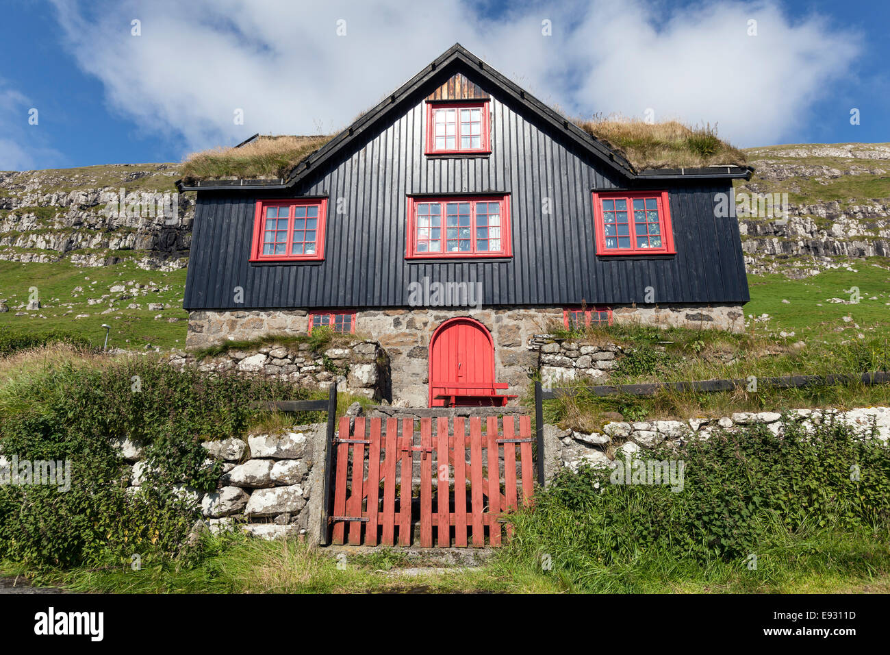 Bunte Holzhaus mit Dach Rasen bedeckt in Kirkjubøur, Streymoy Insel, Färöer Inseln, Stockfoto