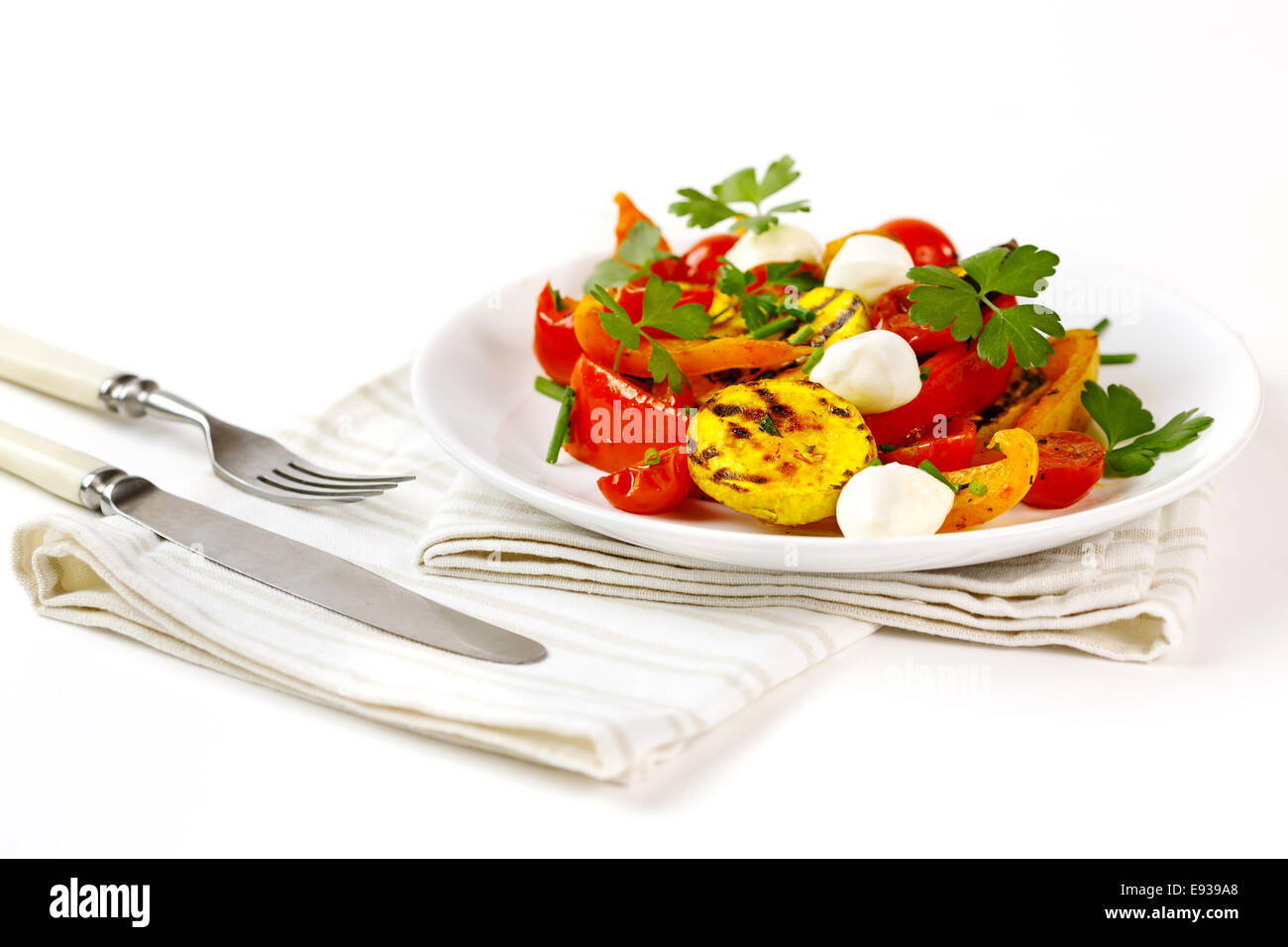 Gegrilltes Gemüse mit Mozzarella-Käse. Cherry-Tomaten, Paprika, Auberginen, Zucchini in weißem Teller auf weißem Hintergrund gedient Stockfoto