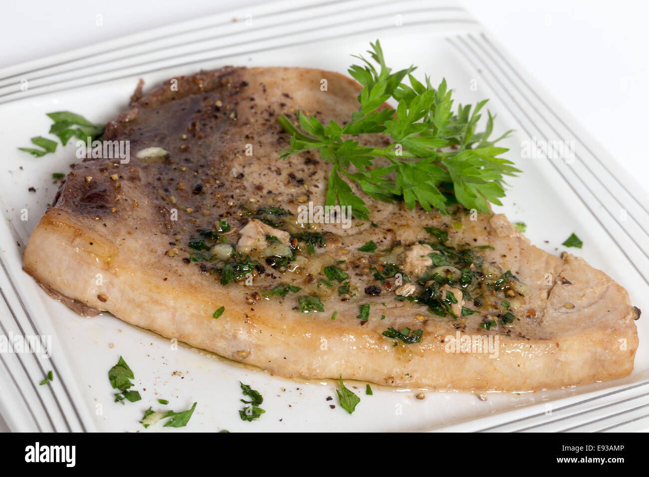 Gebratene Pfeffer-beschichtete Schwertfischsteak mit einer Petersilie, Knoblauchbutter-sauce. Stockfoto