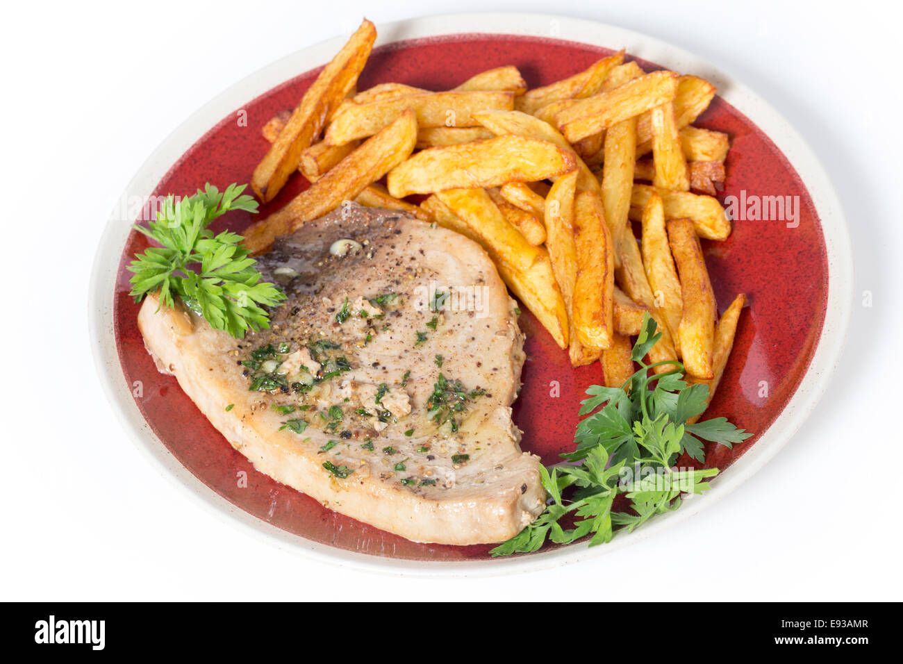 Schwertfischsteak zubereitet auf einem Teller mit Pommes Frites und einem Petersilie und Knoblauch-Butter-Sauce, die von der Seite gesehen Stockfoto