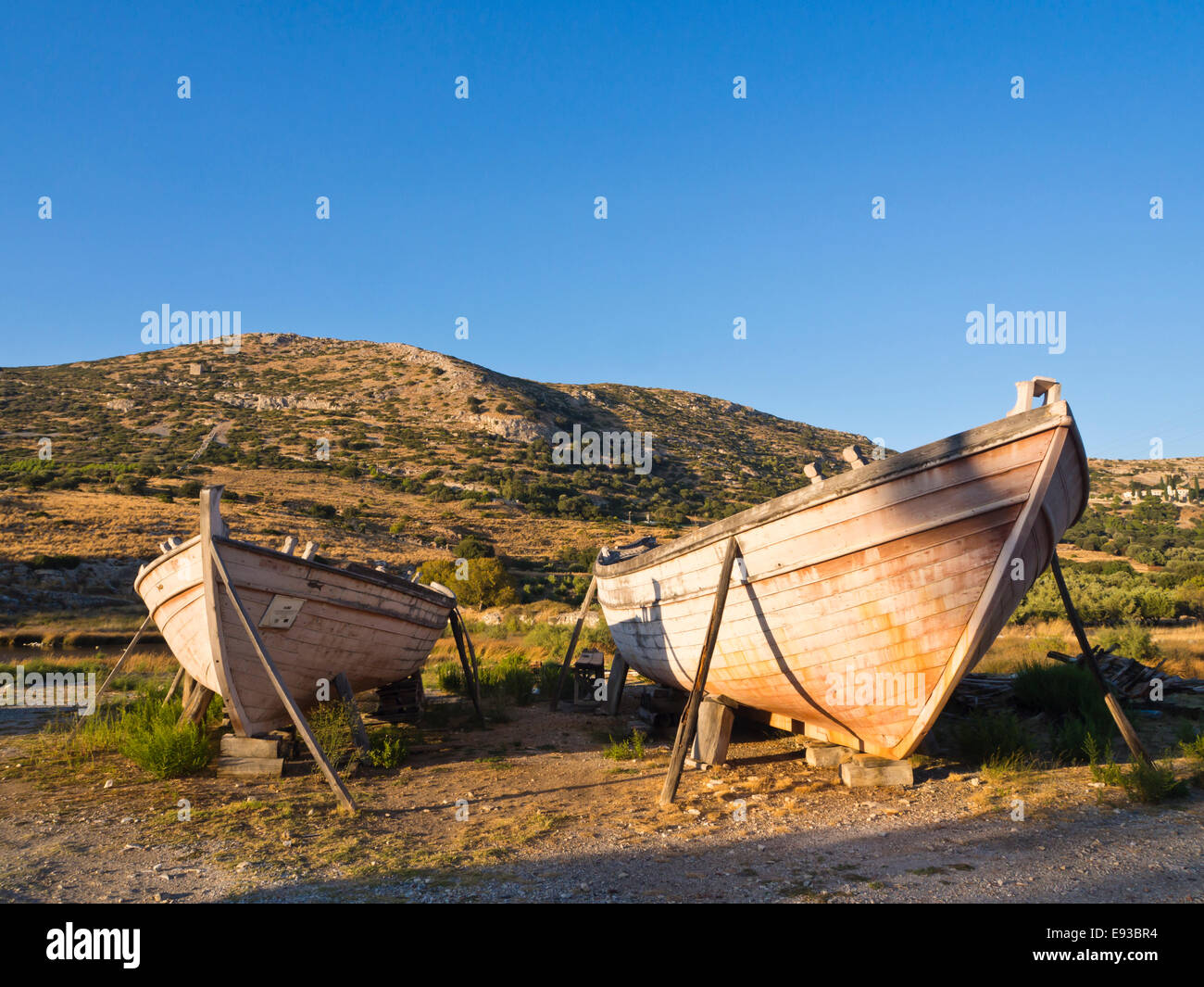 Griechischen hölzerne Angeln Bootsrümpfe platziert als am Straßenrand Dekoration, goldene Abendlicht färben die Landschaft, Samos Griechenland Stockfoto