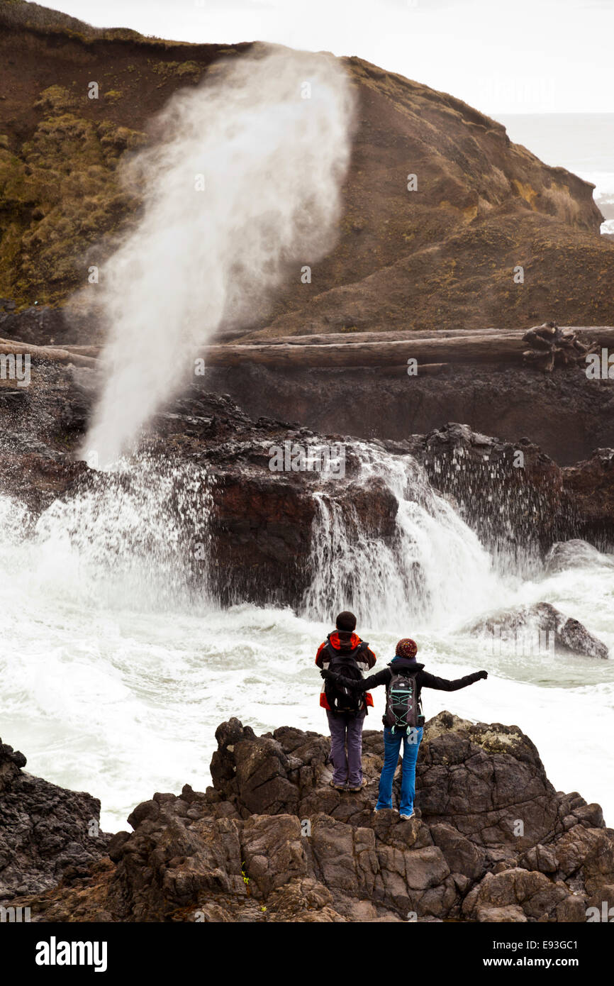 Zwei Wanderer sehen Spouting Horn auf einen schmalen Meeresarm des Pazifischen Ozeans in Lincoln County, Oregon, Vereinigte Staaten von Amerika, Stockfoto