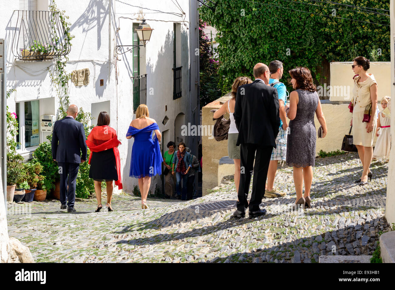 Gut gekleidete Menschen verlassen eine Kirche nach der Teilnahme an einer Hochzeit in der Stadt Cadaques, Costa Brava. Stockfoto