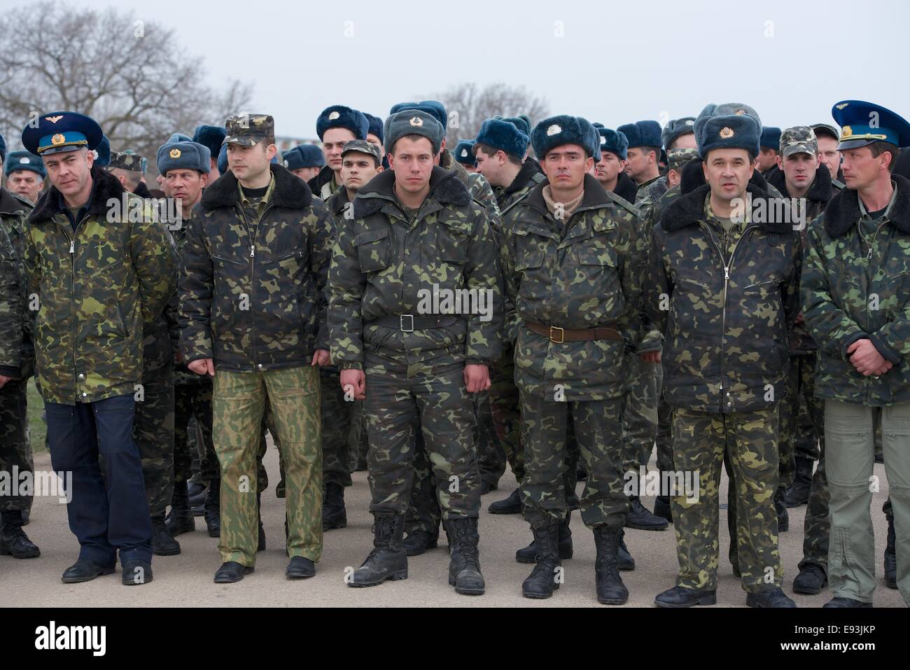 Unbewaffnete ukrainischen Flieger sind umgeben von bewaffneten russischen Truppen auf dem Flug Linie an Belbek Airbase auf der Krim Stockfoto