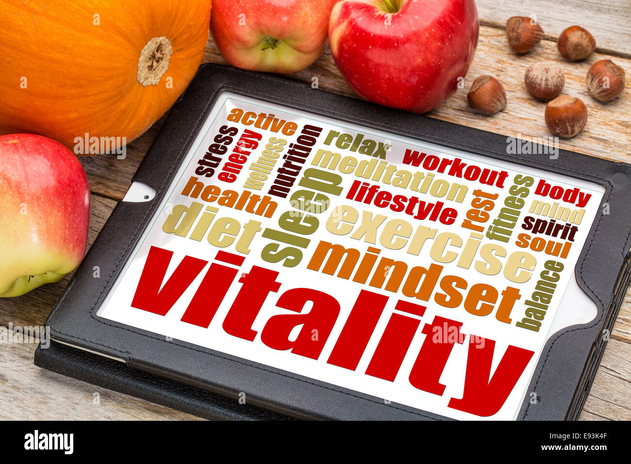 Vitalität und Lebensenergie Wortwolke auf digitale Tablett mit Äpfel, Kürbis und Haselnüssen Stockfoto