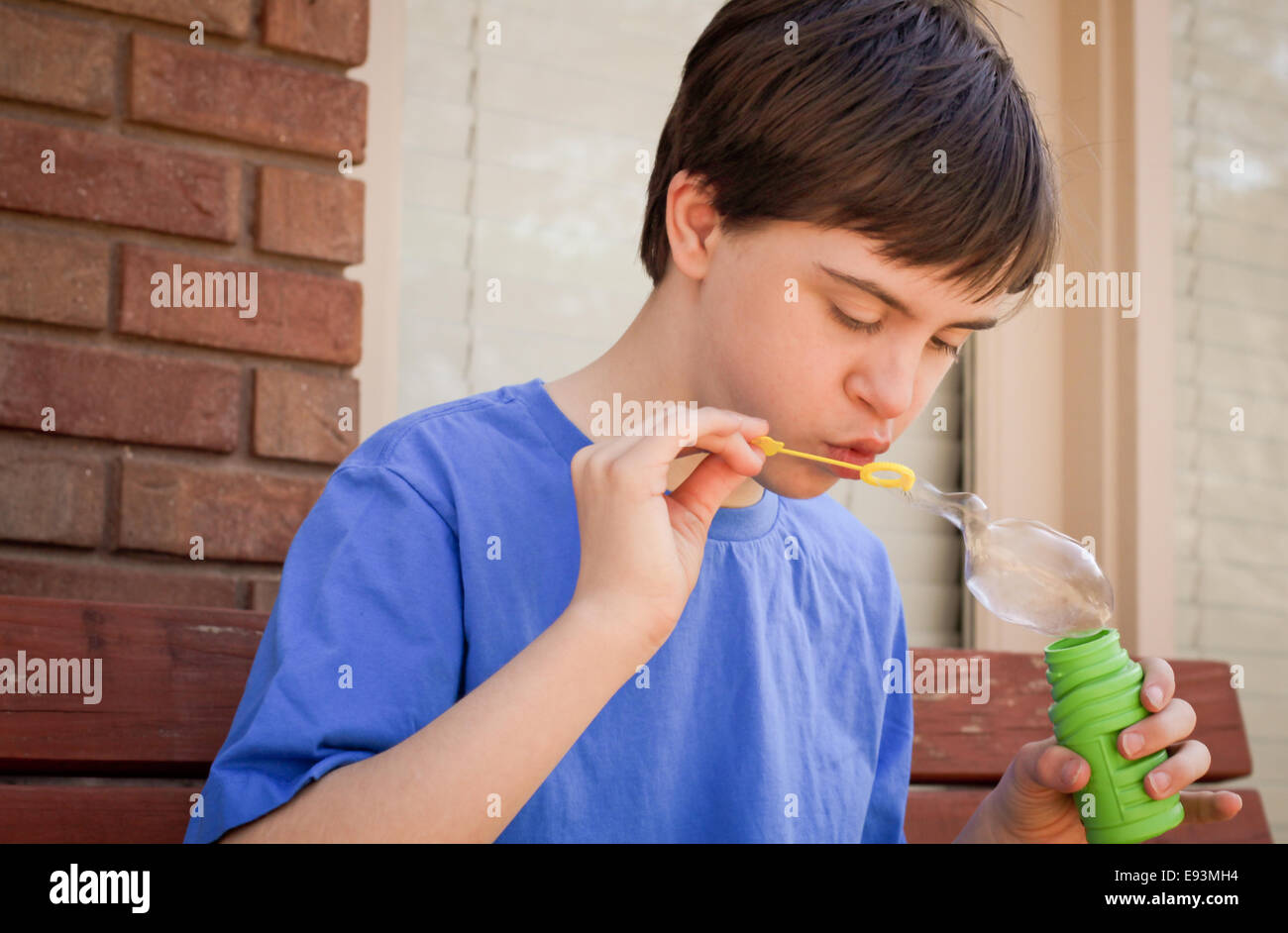 Hübsches Kind mit Autismus und Down-syndrom Seifenblasen Stockfoto