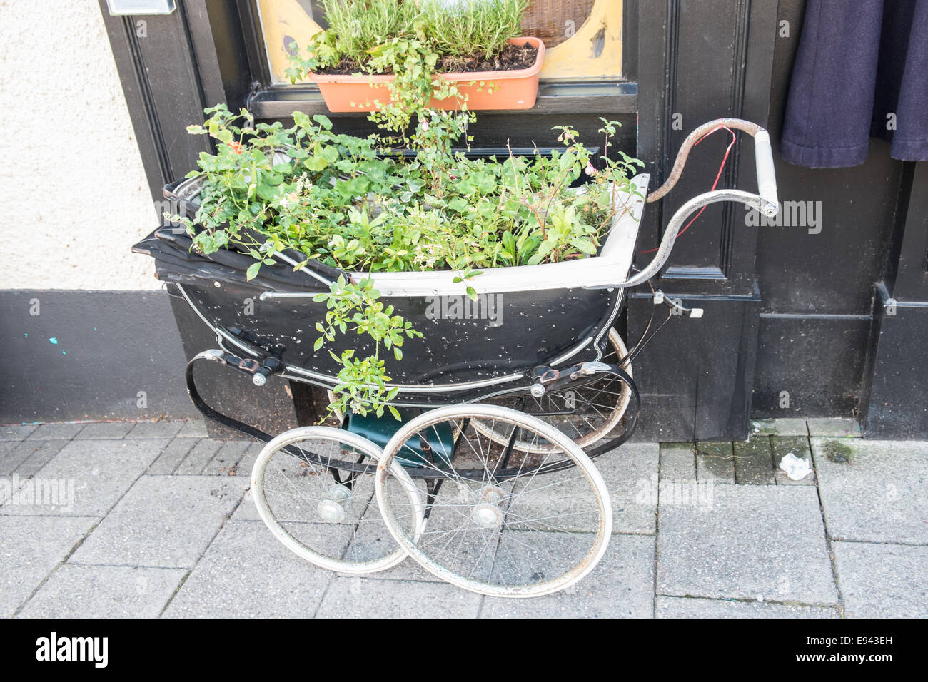 Im alten Stil modische Vintage, antike Kinderwagen, Kinderwagen recycelt, wiederverwendet, als Pflanze Inhaber Topf außerhalb des Shops in Narbeth, Pembrokeshire, Wales, West Wales, Walisisch, Großbritannien Stockfoto