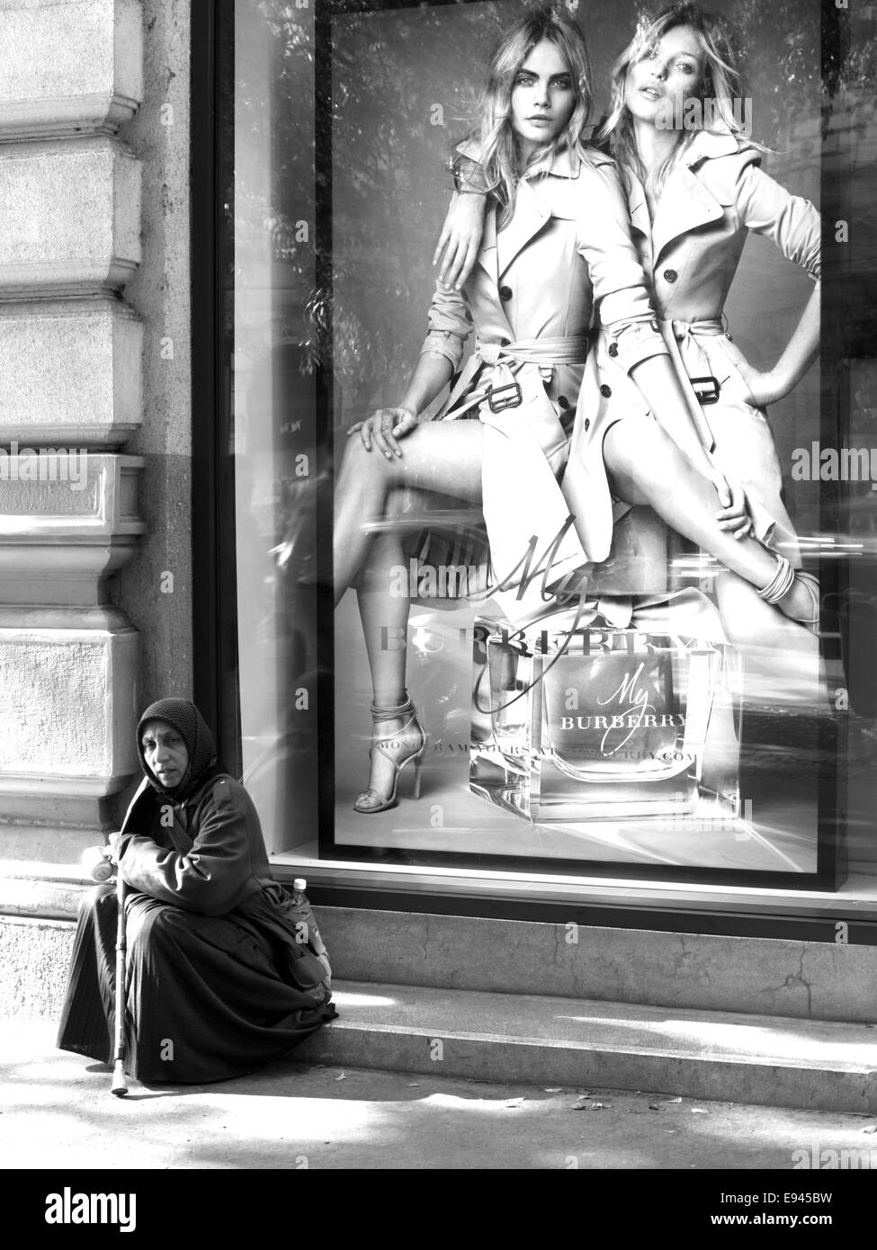 Frau sitzt vor einer eleganten Mode Fenster Bettler Stockfoto
