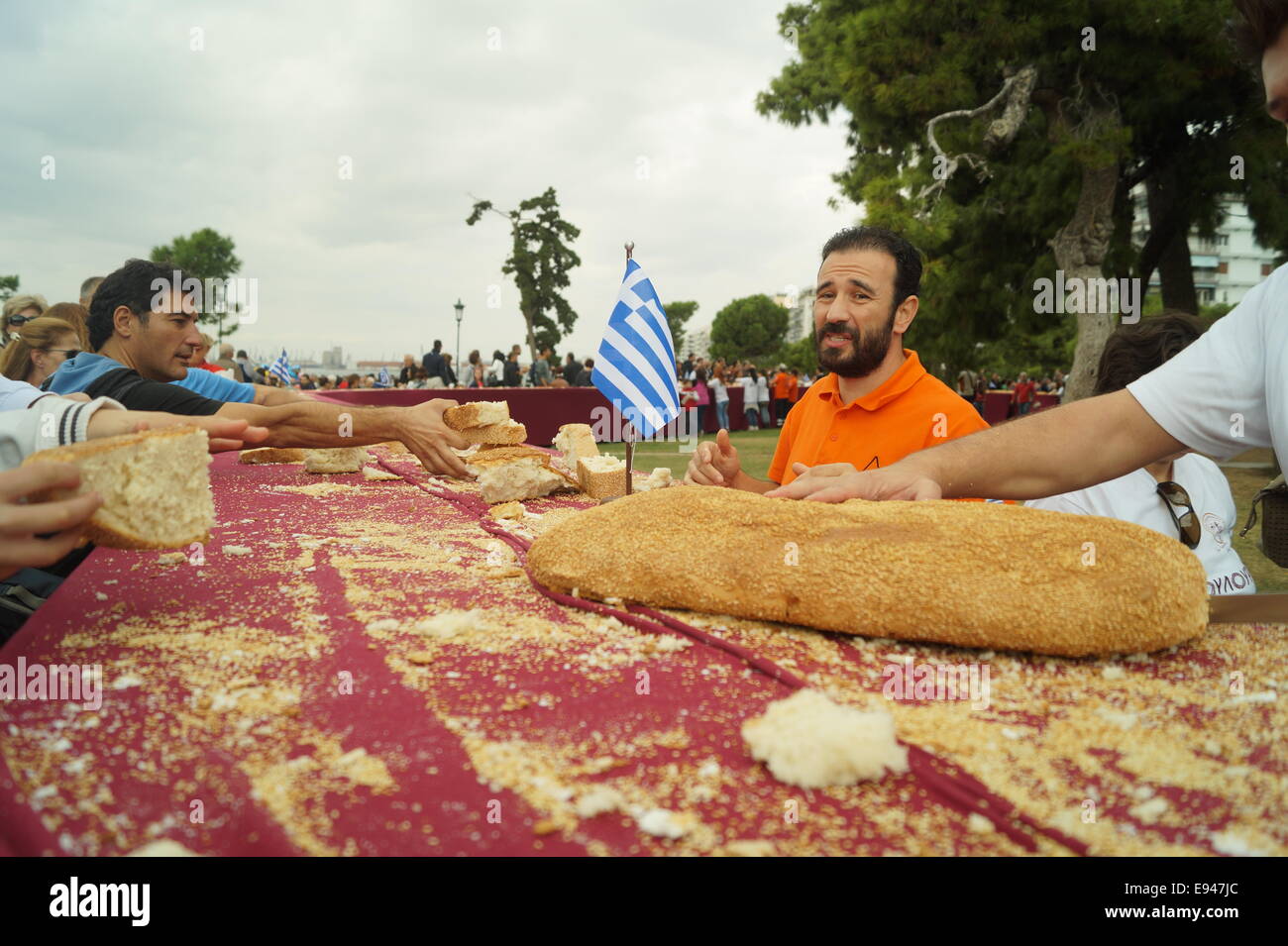 Thessaloniki, Griechenland. 19. Oktober 2014.  Die Leute bekommen kostenlose Brot am Ende der Veranstaltung. Bäcker aus Nordgriechenland errichtet eine 150 Meter lange "Koulouri" (eine traditionelle griechische Sesam-beschichtete Brot) in der zweitgrößten Stadt Thessaloniki, Griechenland.  Die Bäcker umgeben der Stadt ikonischen weißen Turm um einen Guinness-Rekord der weltweit längste Koulouri je gemacht Credit zu erreichen: Orhan Tsolak Alamy Live News Stockfoto