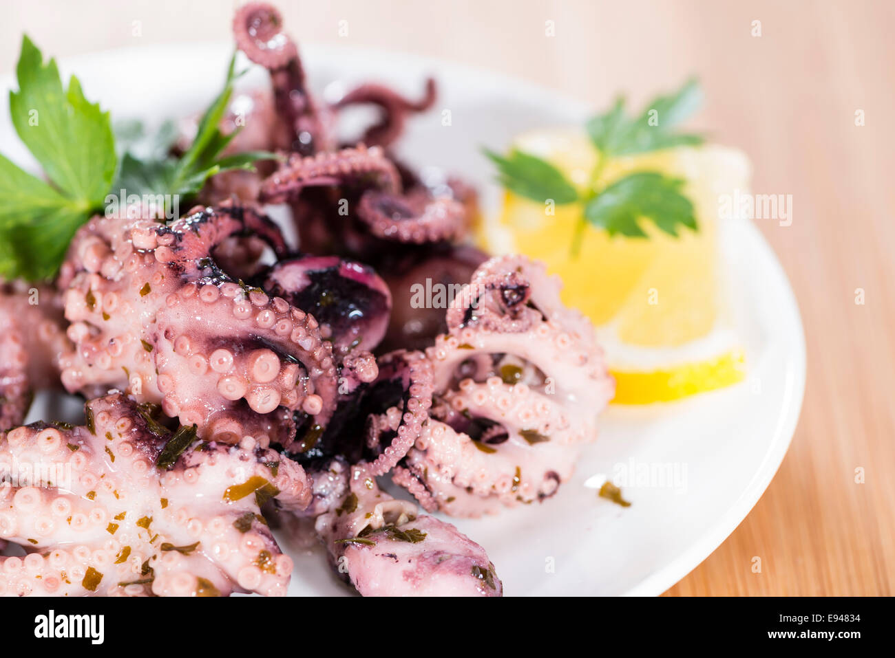 Teil des Oktopus-Salat (mit frischen Kräutern und Knoblauch) auf hölzernen Hintergrund Stockfoto