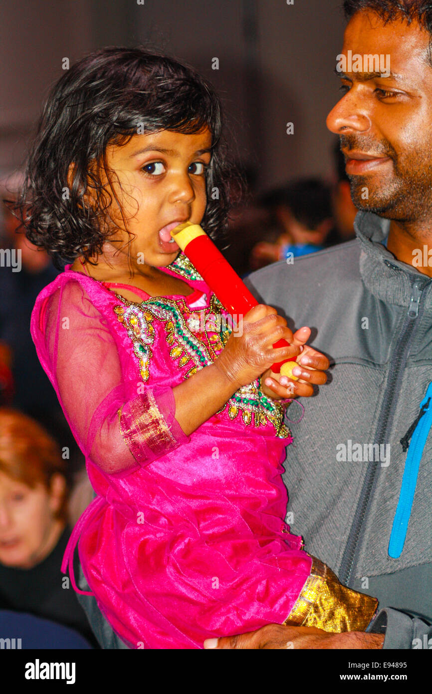 junge Mädchen von ihrem Vater indisches Kind in rosa indischen Kleid mit Pfiff Spielzeug gehalten Stockfoto