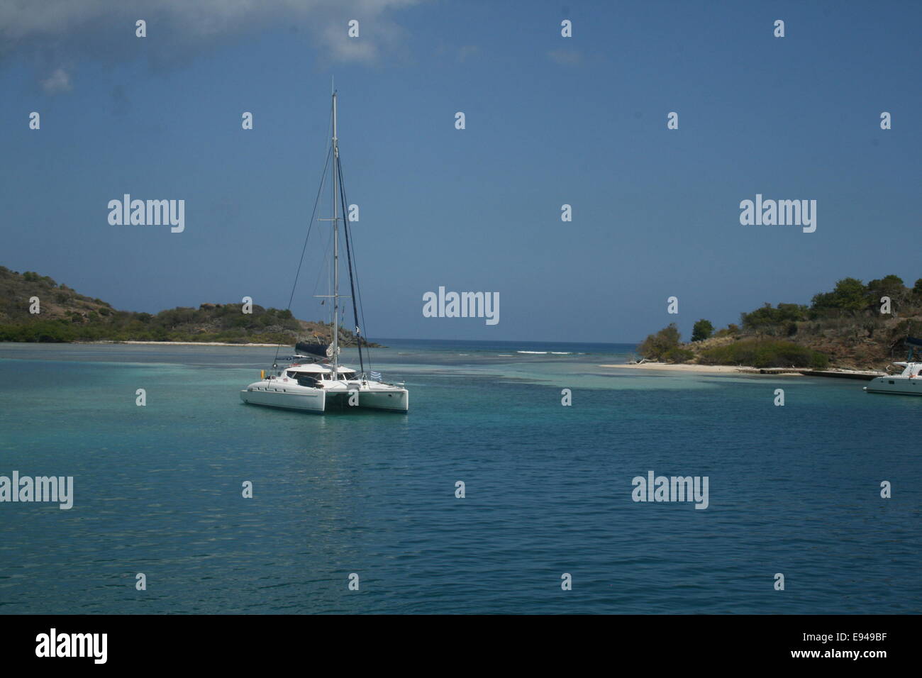 Eine Katamaran-Segelyacht Anker in einer abgeschiedenen und ruhigen Bucht in den British Virgin Islands in der Karibik. Stockfoto