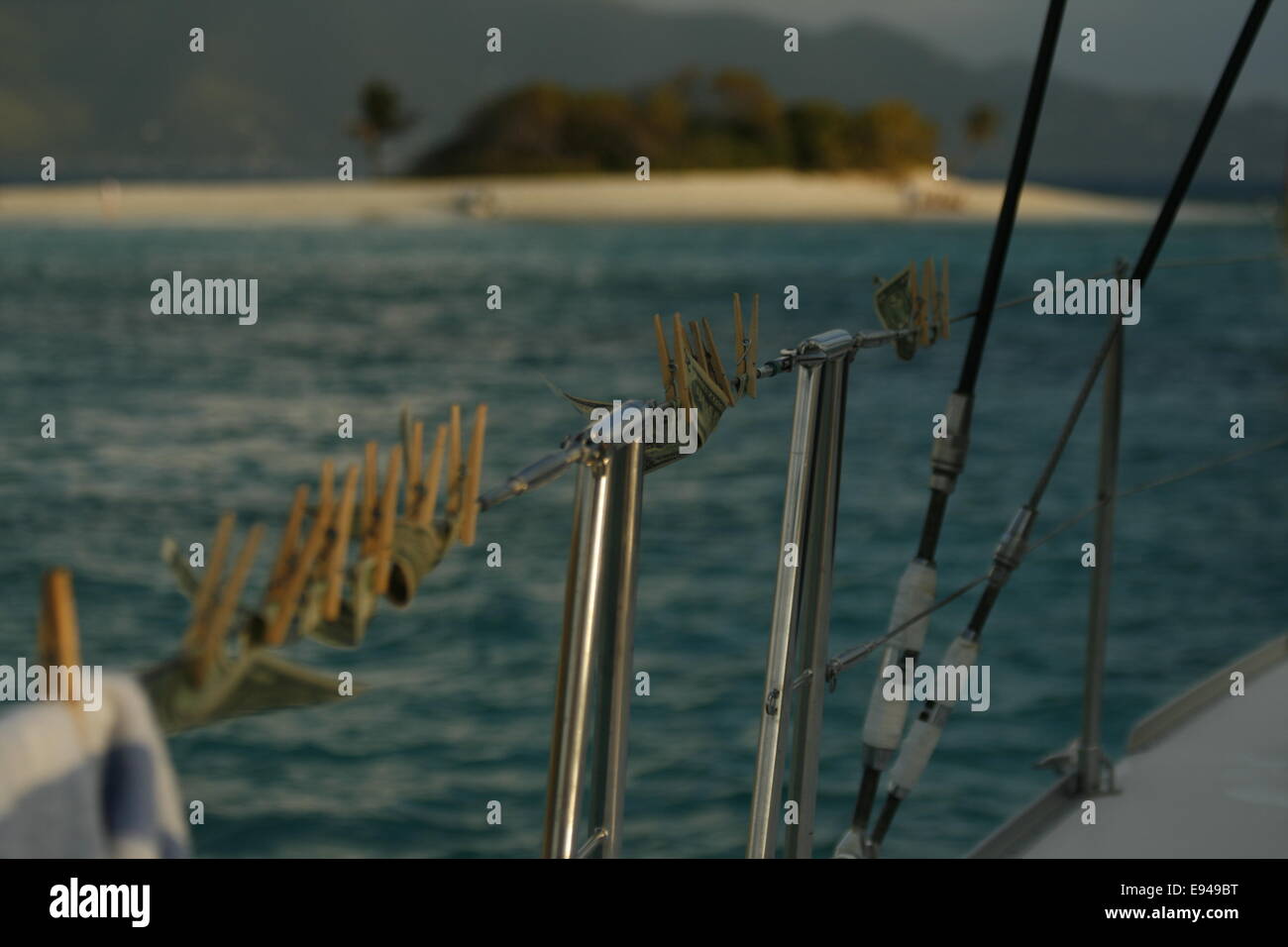 Geld Trocknung auf die seitlichen Schienen einer Yacht auf den BVI, Karibik mit einer Insel im Hintergrund. Stockfoto