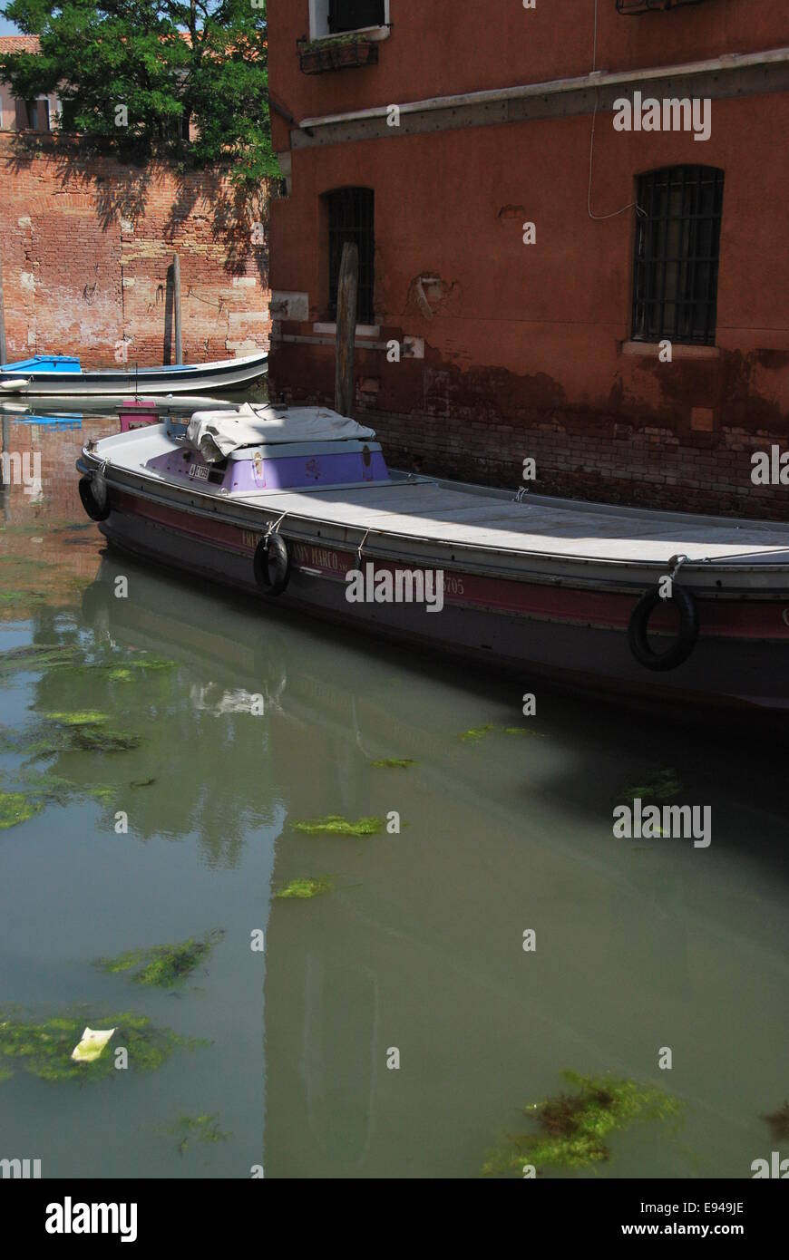 Italien. Venedig. Kanal-Szene. alte Boote. abgenutzte Holz, Mauerwerk bröckelt.  Reflexionen, Bewegung. zu beruhigen. Stockfoto