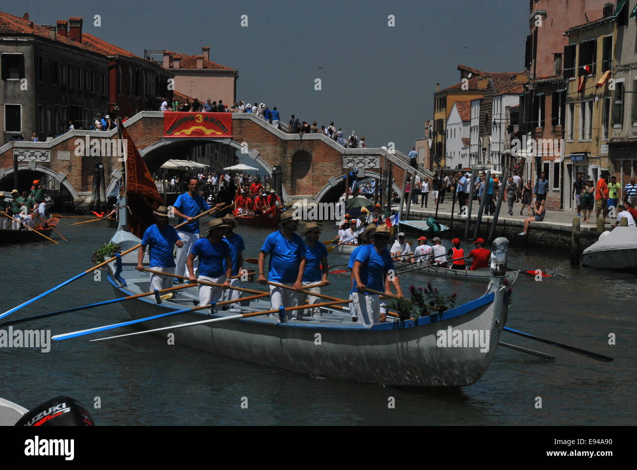 Italien. Venedig. Vogalonga 2014. Große und Kanus. Ruder. Warteschlange unter Brücke bekommen. Chaos. Blick durch die Brücke. Ruderer. Stockfoto