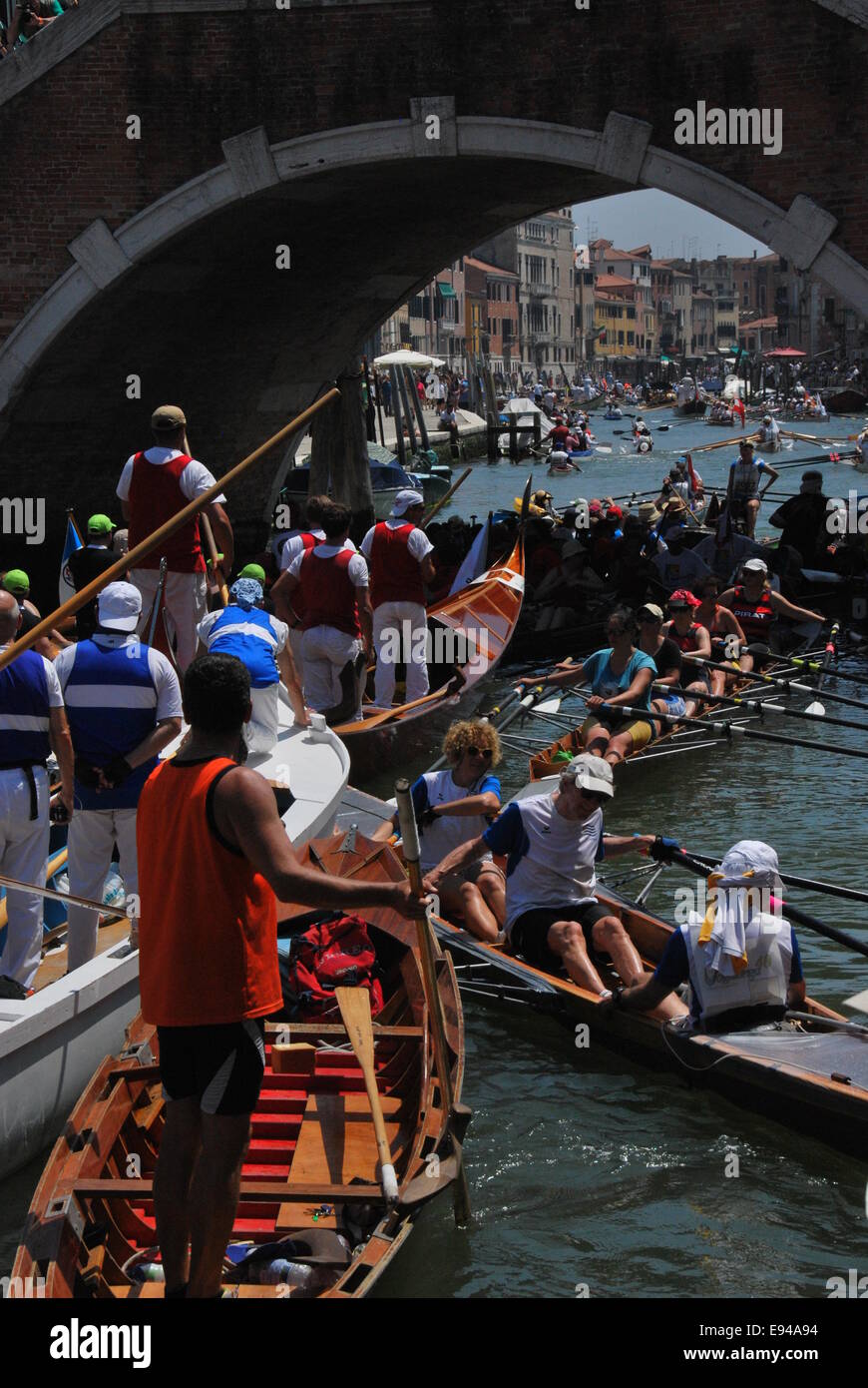 Italien. Venedig. Vogalonga 2014. Große und Kanus. Ruder. Warteschlange unter Brücke bekommen. Chaos. Blick durch die Brücke. Ruderer. Stockfoto