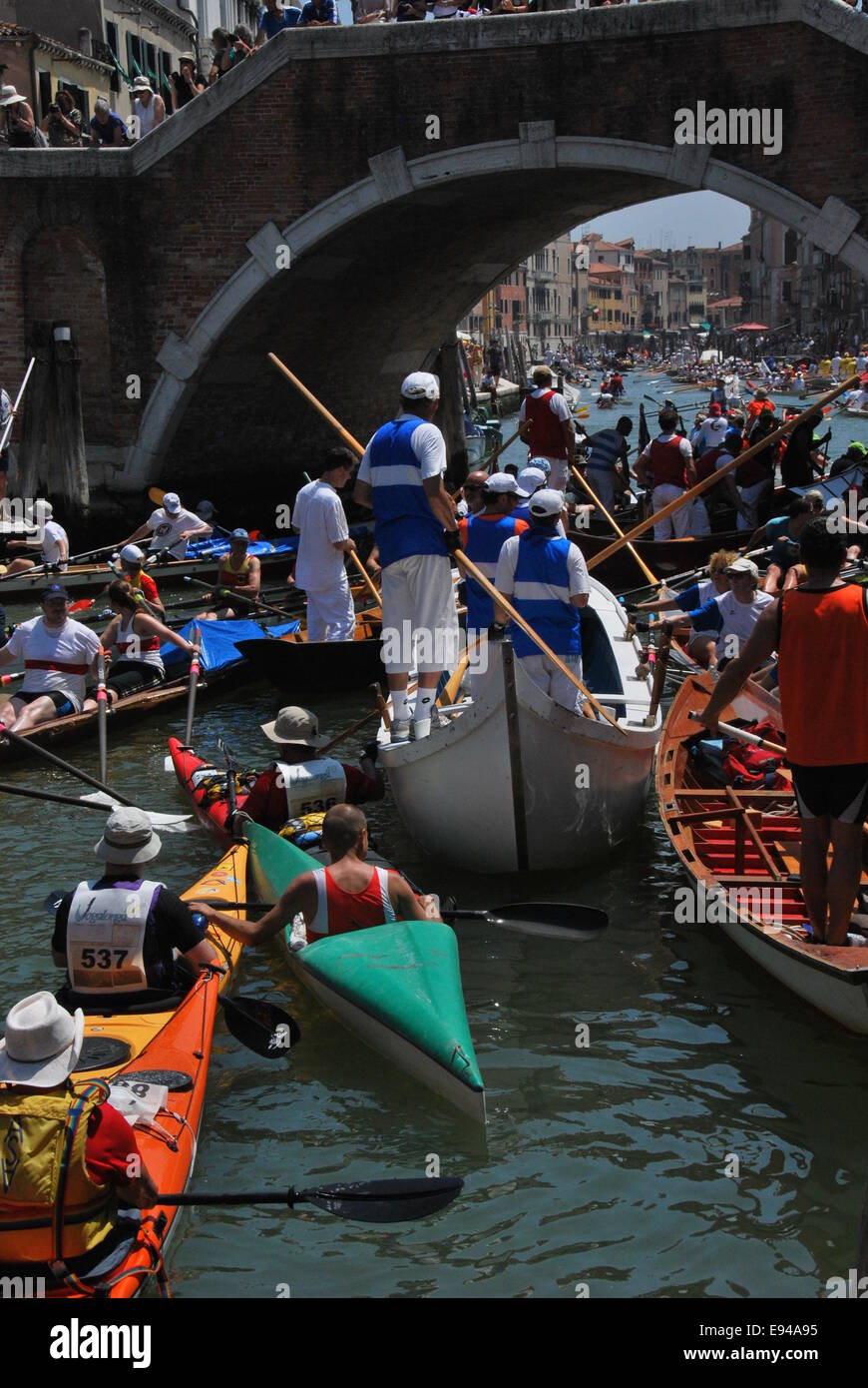 Italien. Venedig. Vogalonga 2014. Große und Kanus. Ruder. Warteschlange unter Brücke bekommen. Chaos. Blick durch die Brücke. Stockfoto