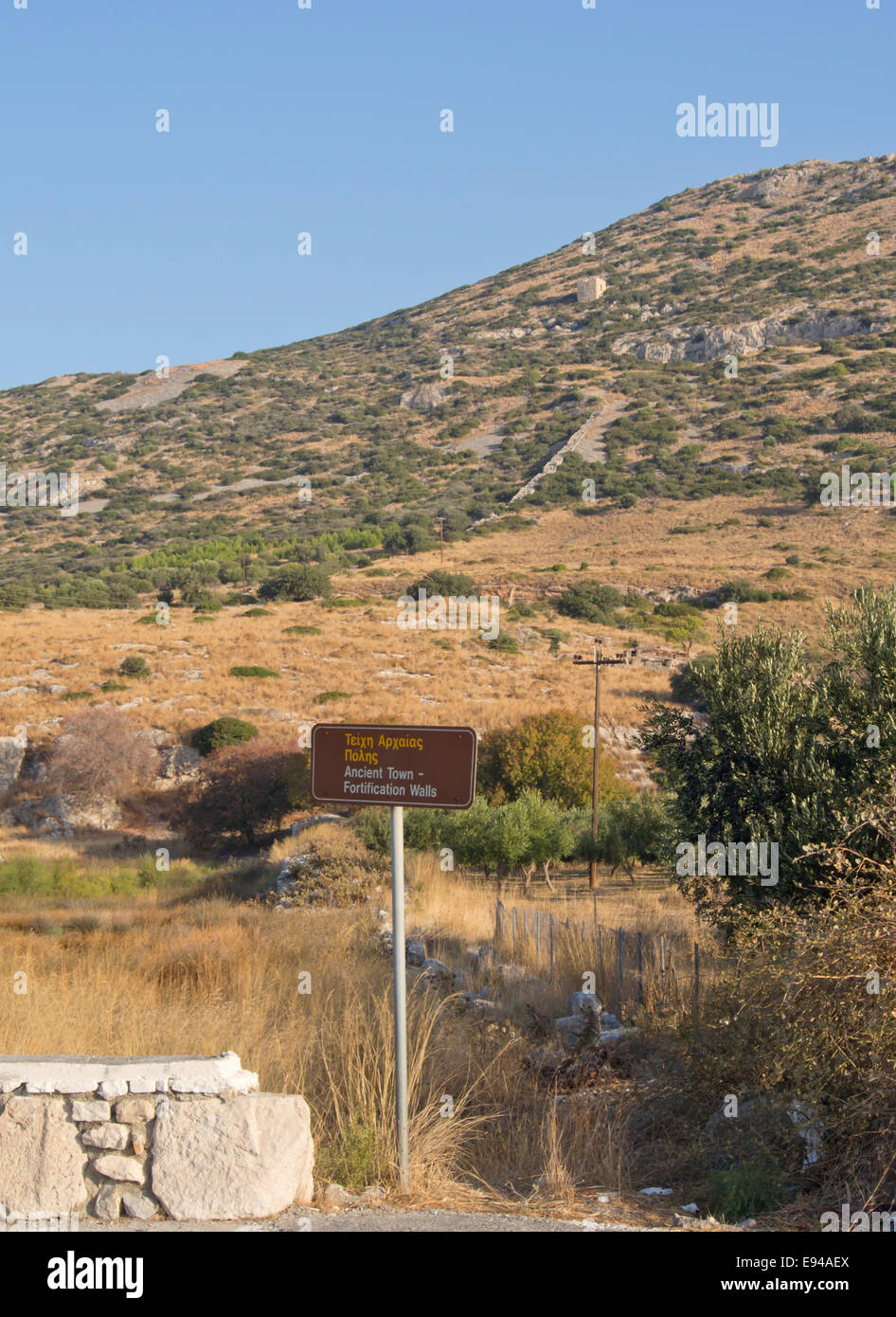 Überbleibsel der alten Stadtmauer mit Wegweiser der üppigen Landschaft der Phytagoreion ein Dorf in der Insel Samos Griechenland Stockfoto